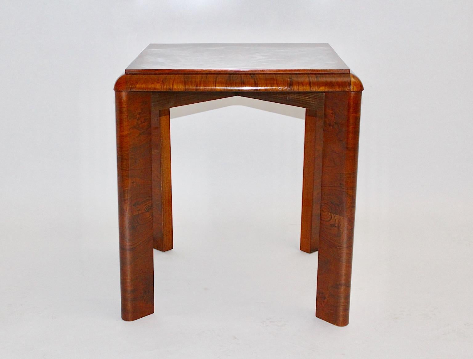 Art Deco vintage side table or coffee table warm brown color made of spruce veneered with walnut 1930s, Austria.
A square like table top shows a lively walnut veneer with burl wood in smooth and warm color and four legs with slightly curved