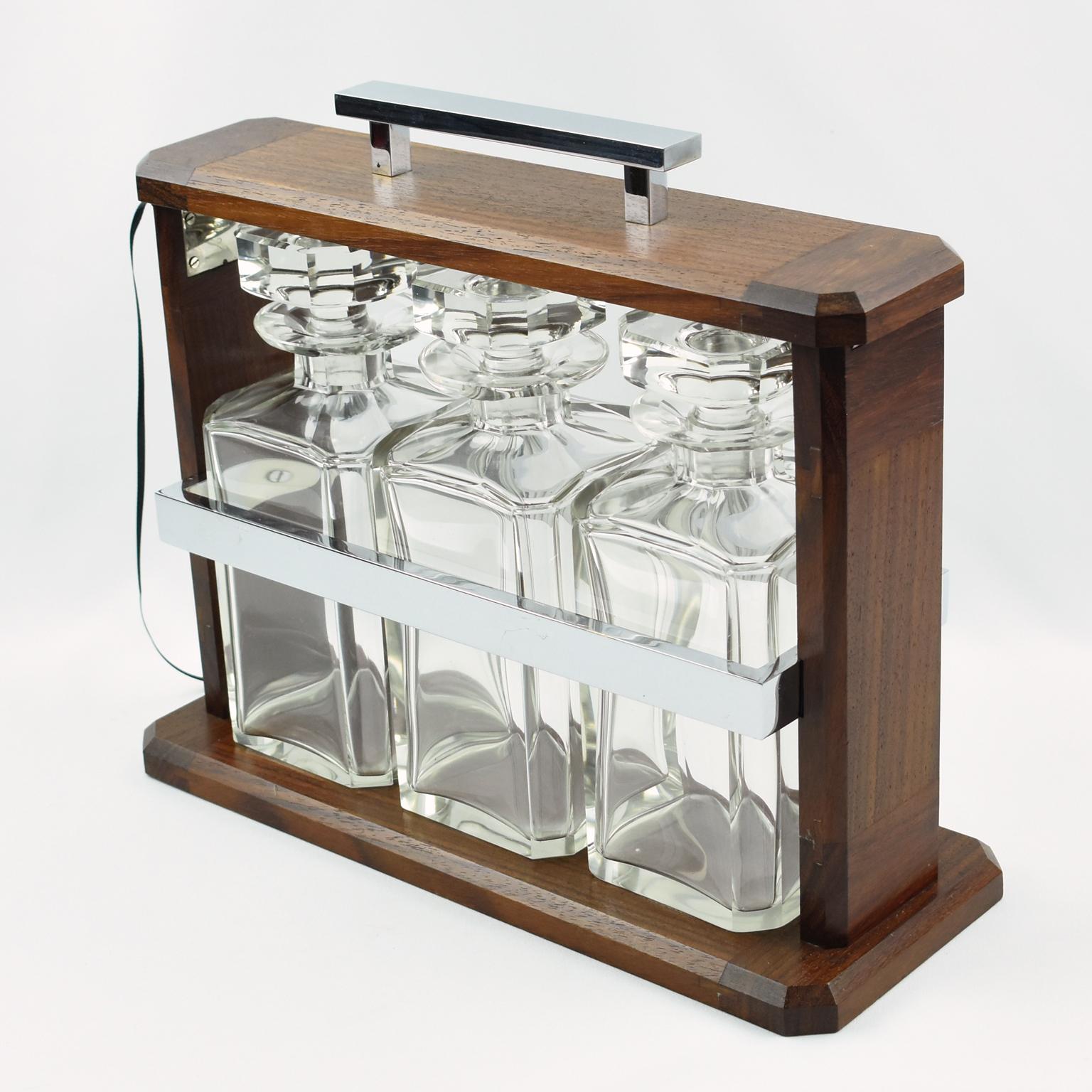 Stunning Art Deco tantalus or cave a liqueur, barware accessory. The geometric mounted case is made of solid walnut with chromed metal holding sides and handle. Three crystal decanters with faceted stopper are held in place in a chrome compartment.