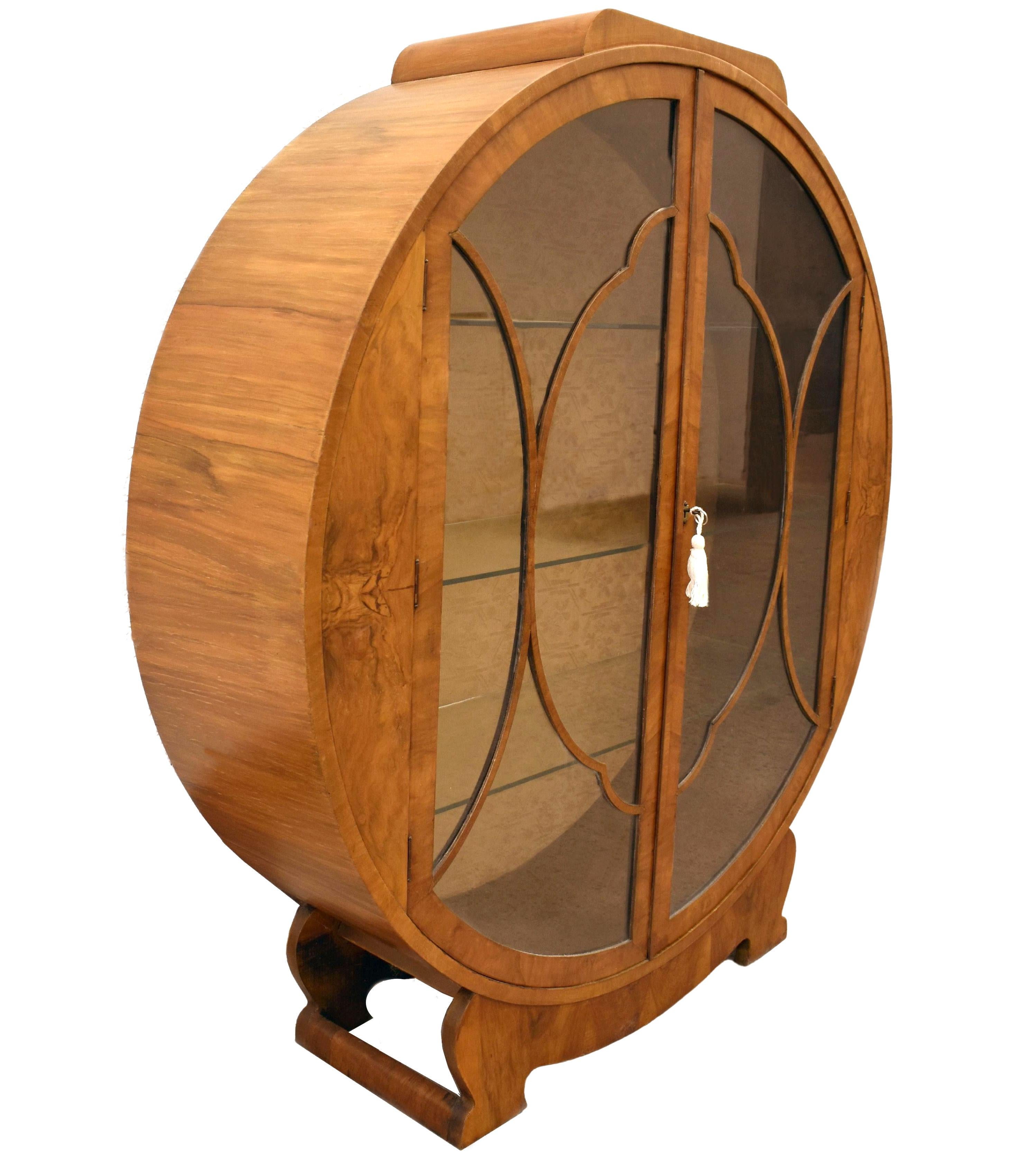 Fabulous, original 1930s Art Deco display cabinet. This lovely figured walnut veneered honey mid-tone walnut. The cabinet features a generously sized interior display area for your 'collections'. Very attractive cloud shape astragal to the glass to