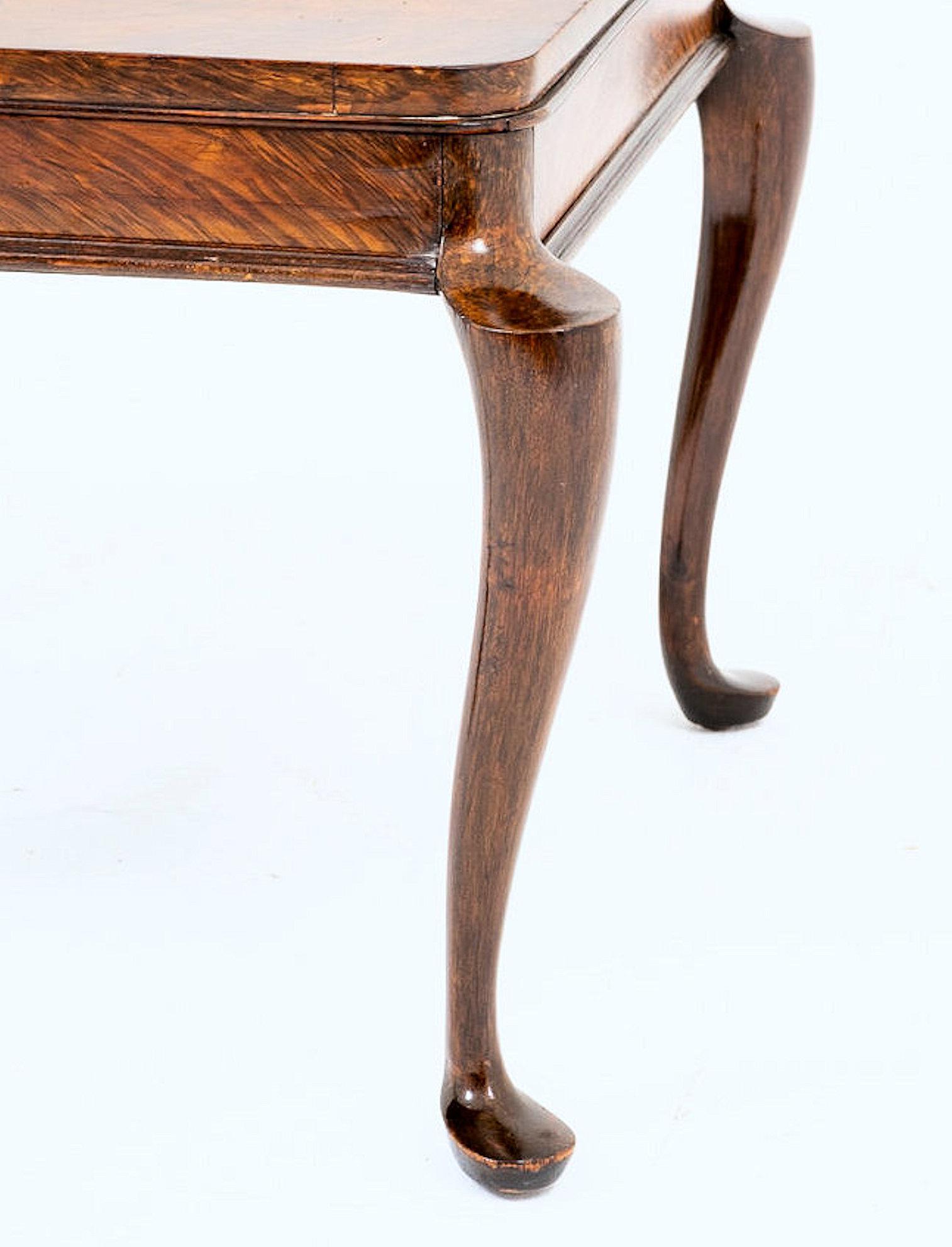 This lovely and elegantly designed early 20th century table features a Bookmatched pattern of figured walnut veneers. The table stands on 4 gracefully shaped cabriole legs, with a ‘sculpted’ top and ending on pad feet. It measures 19 in – 48.2 cm in