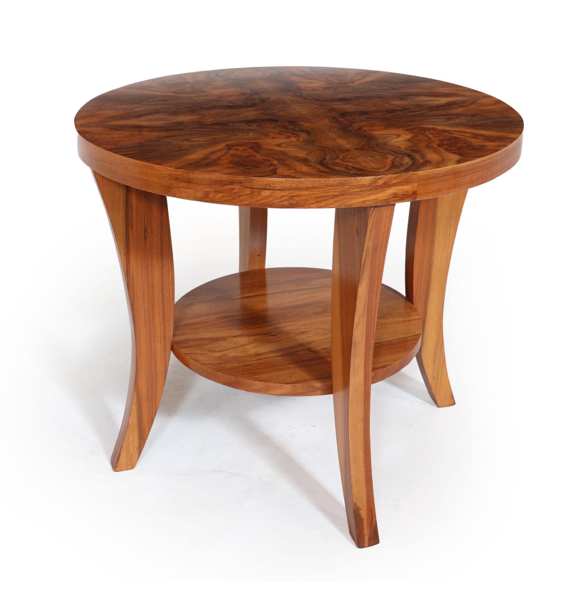 Art Deco walnut coffee table.
A circular figured walnut center coffee table, produced in France in the 1930’s, the table has four saber legs with center lower tier shelf, the table has been full restored and polished and is in excellent condition