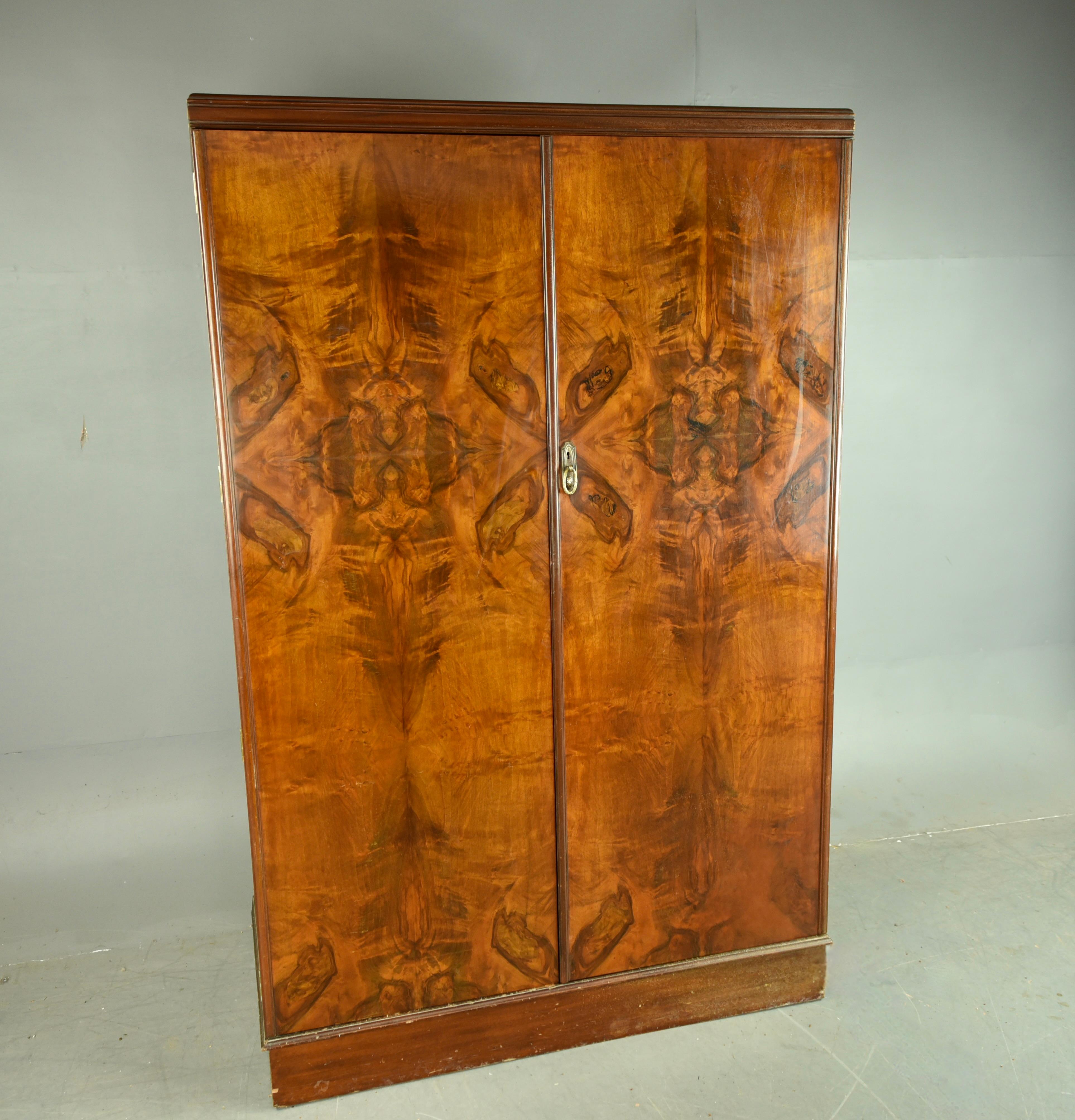 Iconic Art Deco walnut Gentlemens wardrobe The VALET 
The wardrobe has a fully fitted interior with glass fronted drop down shelves drawers and trouser hangers .
The wardrobe is in great condition with some light marks associated with use .
The