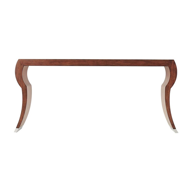 An Art Deco style pacific walnut veneered console table, the rectangular top above solid stylized cabriole end supports with stainless steel cappings and contrasting interior coloring.

Dimensions: 66