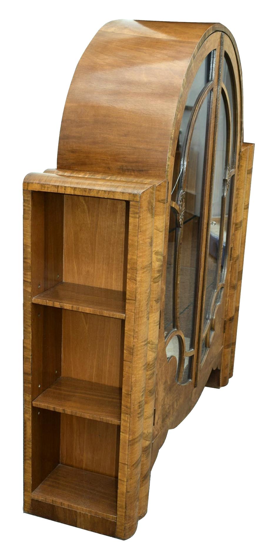 Superb 1930s Art Deco walnut display cabinet. Gorgeous mid-tone walnut, still with original working key and three glass shelves and usable bottom shelf. Generously spaced interior with lined backing. To the sides are bookshelves which can be