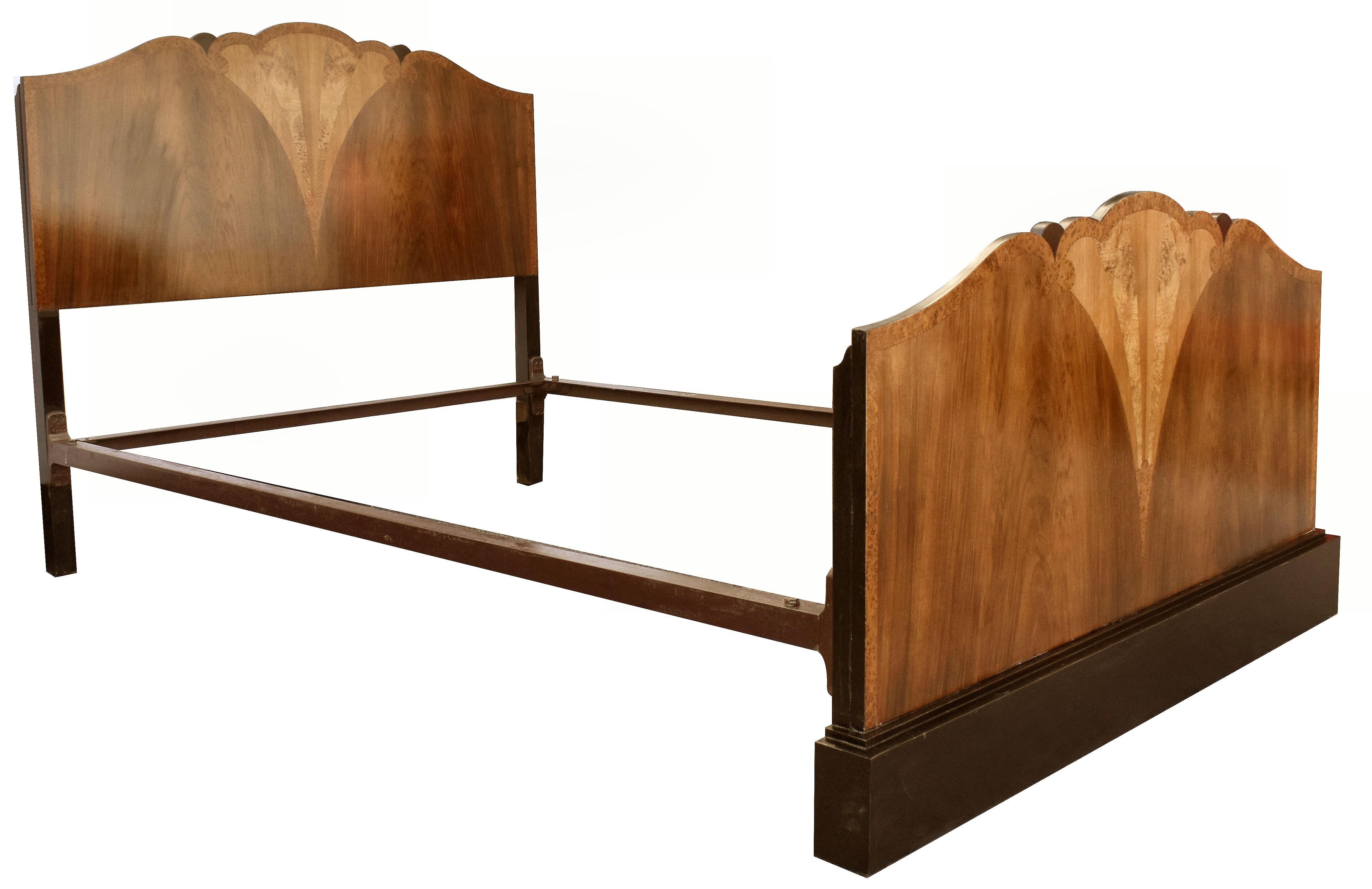 Fabulous 1930's Art Deco Fan shaped walnut bed originating from England. The veneers are so beautifully detailed, the quality exudes from this bed. Features headboard, foot board and two side irons. An ebonized stepped footboard plinth finishes this