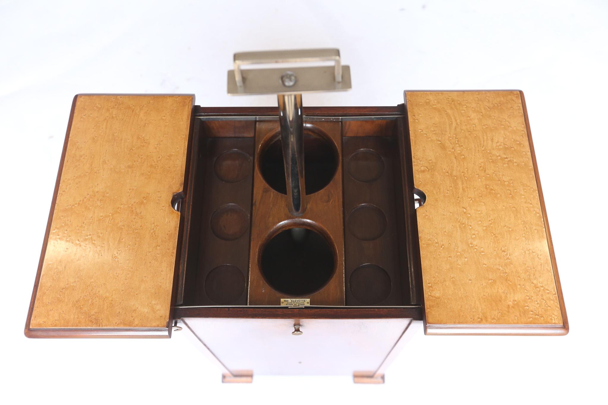 Art Deco Walnut  Elevette  Drinks Cabinet circa 1930s
Retailed by Asprey of London
Chrome plated handle on pole, Pulls up, 
The fitted interior to hold bottles,  elevates up
Chrome hinged fittings attach to the top, 
pair of tops each side flip
