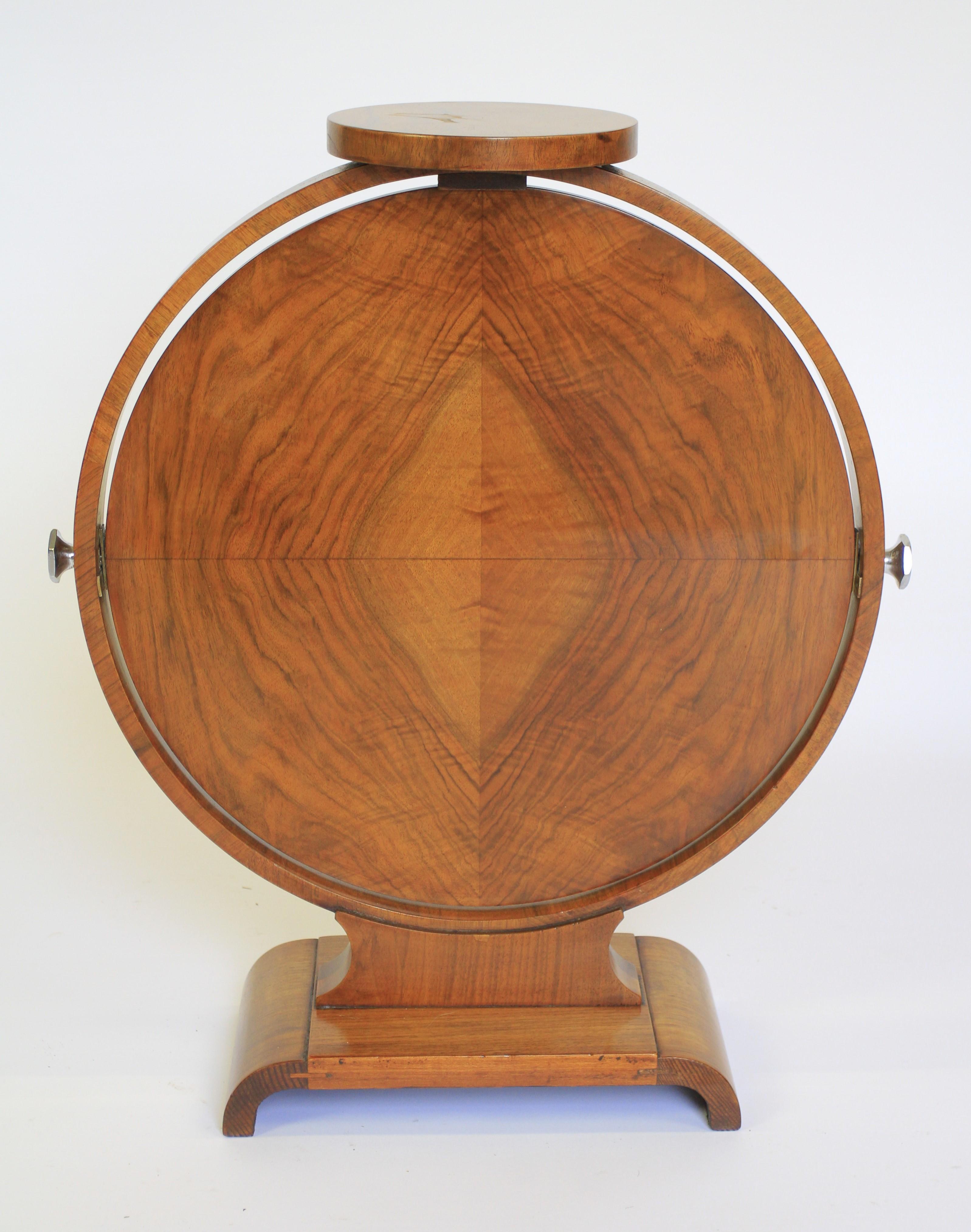 Art Deco Walnut Folding Lamp/Coffee Table circa 1930s
Hoop Shaped Frame , with
Small Walnut Circular top, 18cm diameter
Folding Walnut circular top 46cm diameter. height 35.5cm.
 with 
Chrome Plated Pinch Knobs each side, 
Arch Shaped Platform