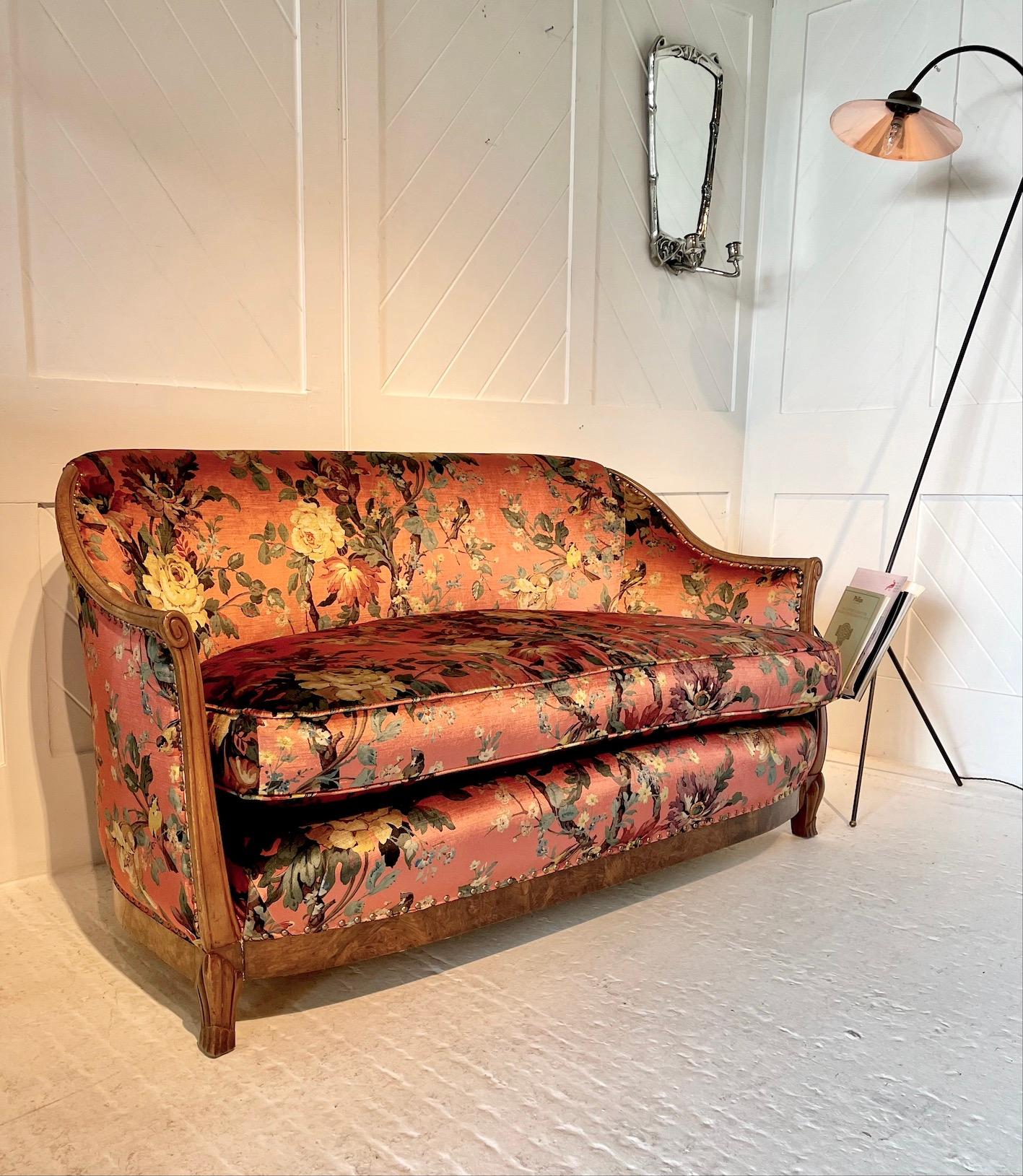 A beautiful example of a curved Art Deco settee which has been inspired by the designs of Jules Leleu

Attributed to Heal & Son

It has a walnut frame with burr walnut skirt

This settee has been re-upholstered in Liberty ’Lady Christina’ floral