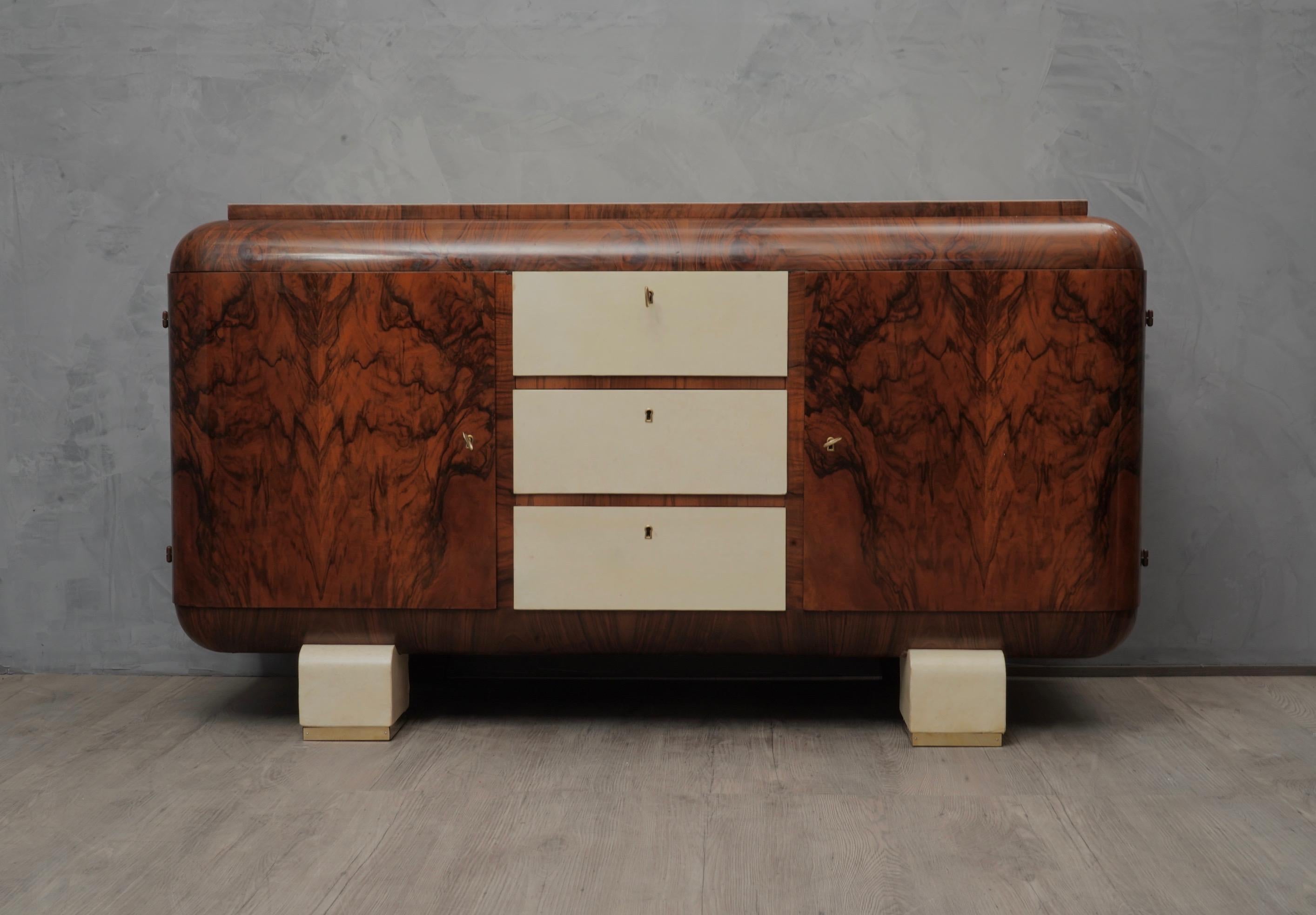 Elegant art deco sideboard where a subtle all over patina emphasizes the grain of the walnut wood, enriched with a fantastic goat skin on the front and top.

The sideboard is veneered in walnut root wood, with top and the front drawers covered in