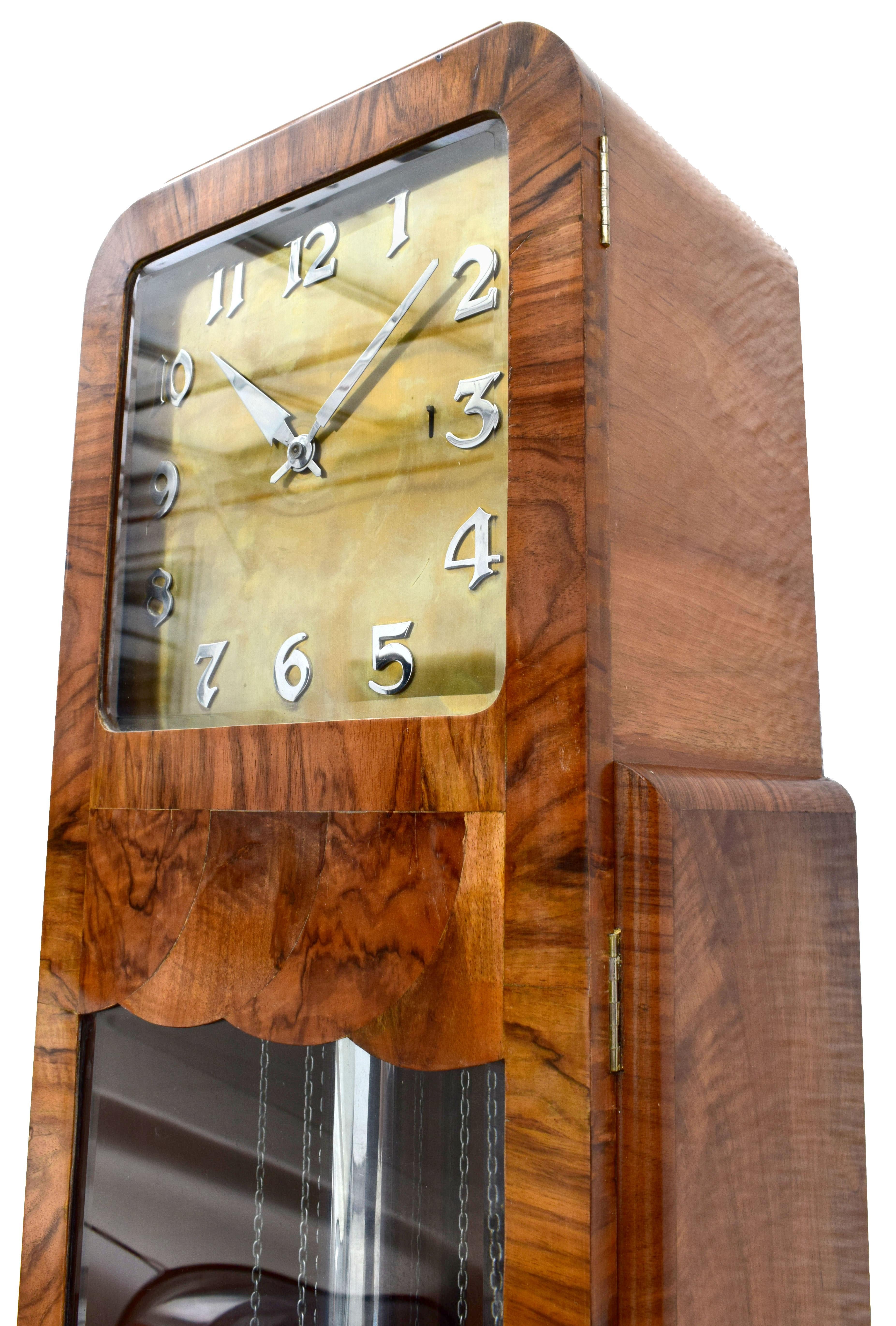 Magnificent Art Deco Grandfather clock dating to the 1930s, England. Extremely hard to source with such great styling. The craftsmanship to the case is spectacular, veneered in a mid tone walnut with beautiful detailing accentuating the shape, no