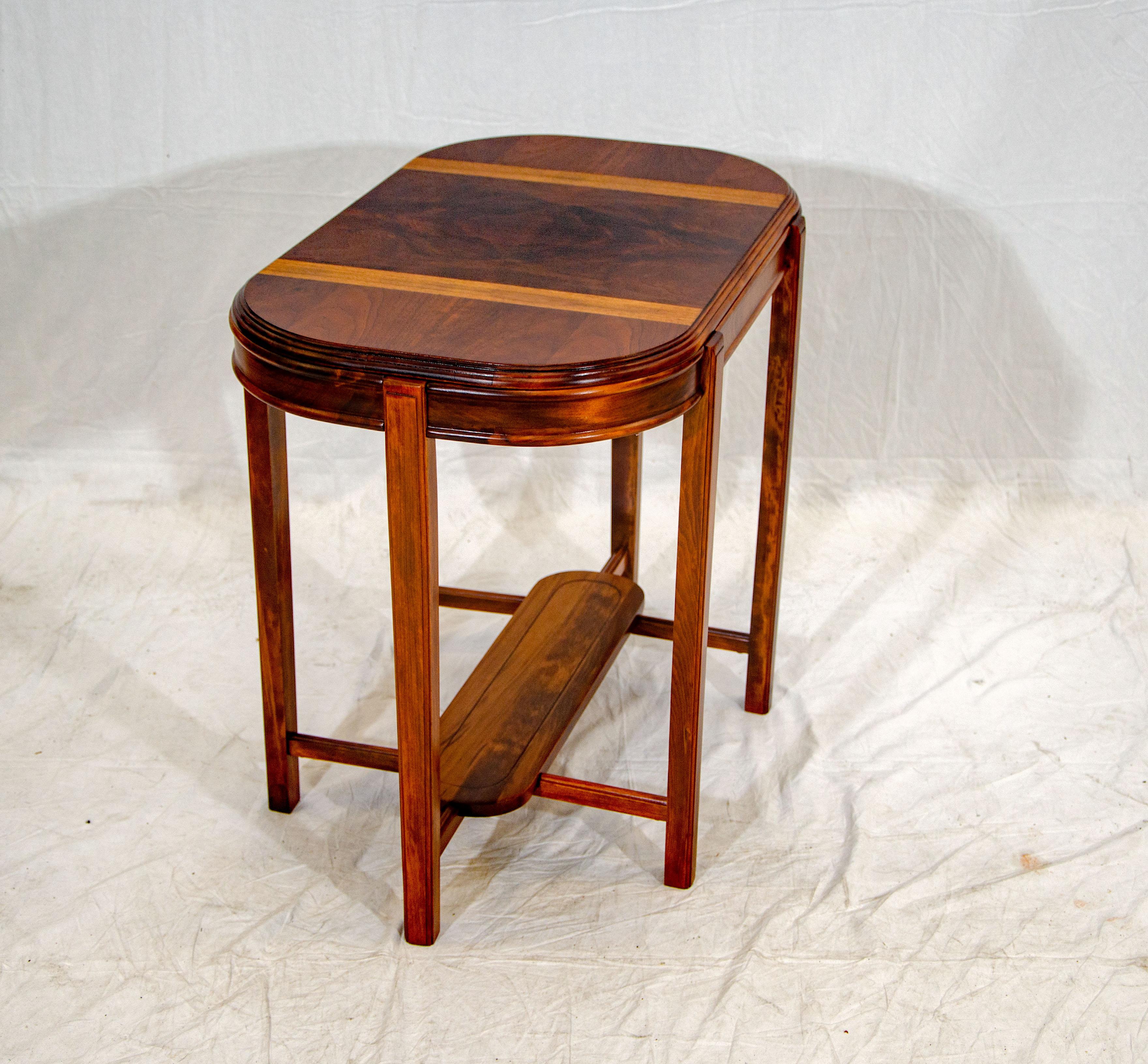 The tabletop has a burled walnut center, bleached walnut stripes, and walnut ends. The accent edges are stepped around the racetrack shaped top. The apron measures 3