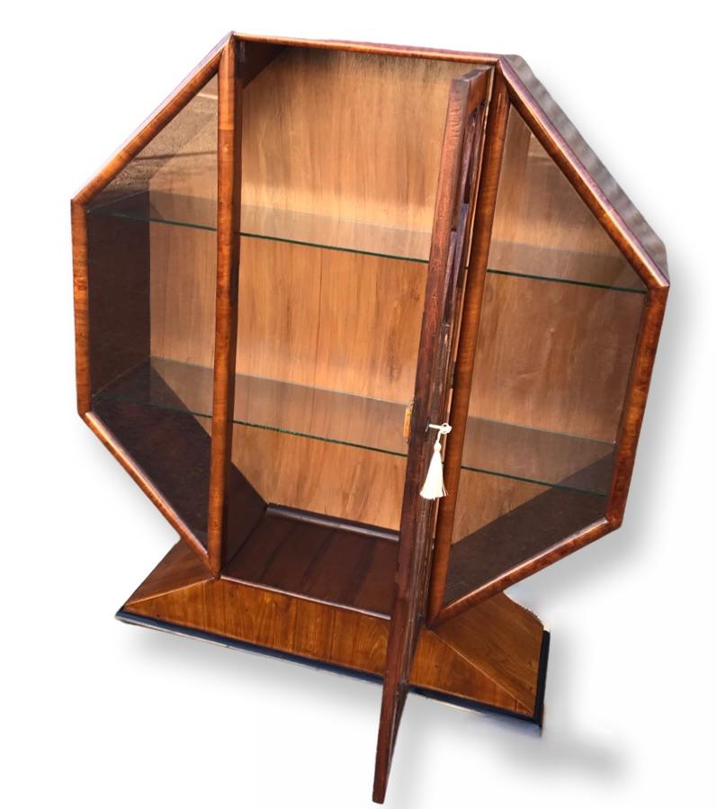 A chance to buy a fabulous Art Deco period 1930’s display cabinet of octagonal form. This beautiful cabinet has just been through our workshops and is presented refinished by hand with traditional French polish. Veneered in walnut, the astragal