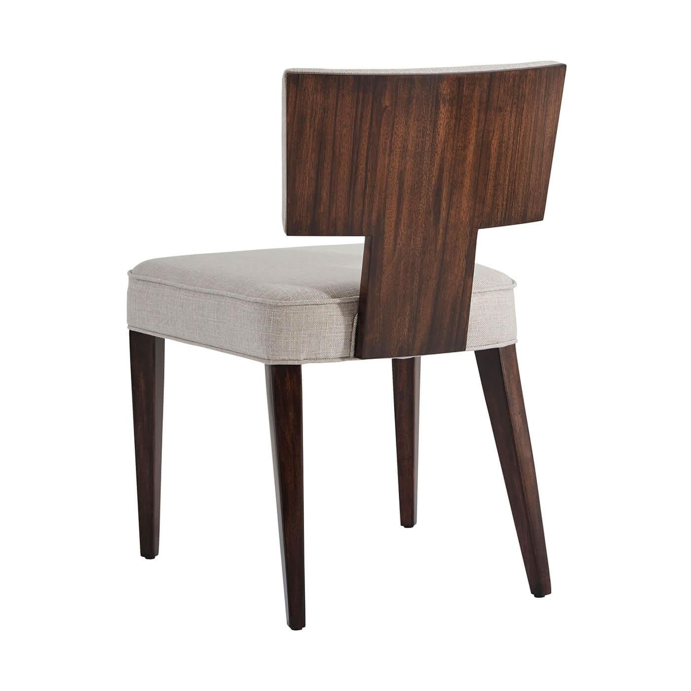 A fine Art Deco style dining chair with Pacific Walnut veneer and mahogany, with an upholstered seat and backrest and with a veered and finished reverse.

Dimensions: 21.5