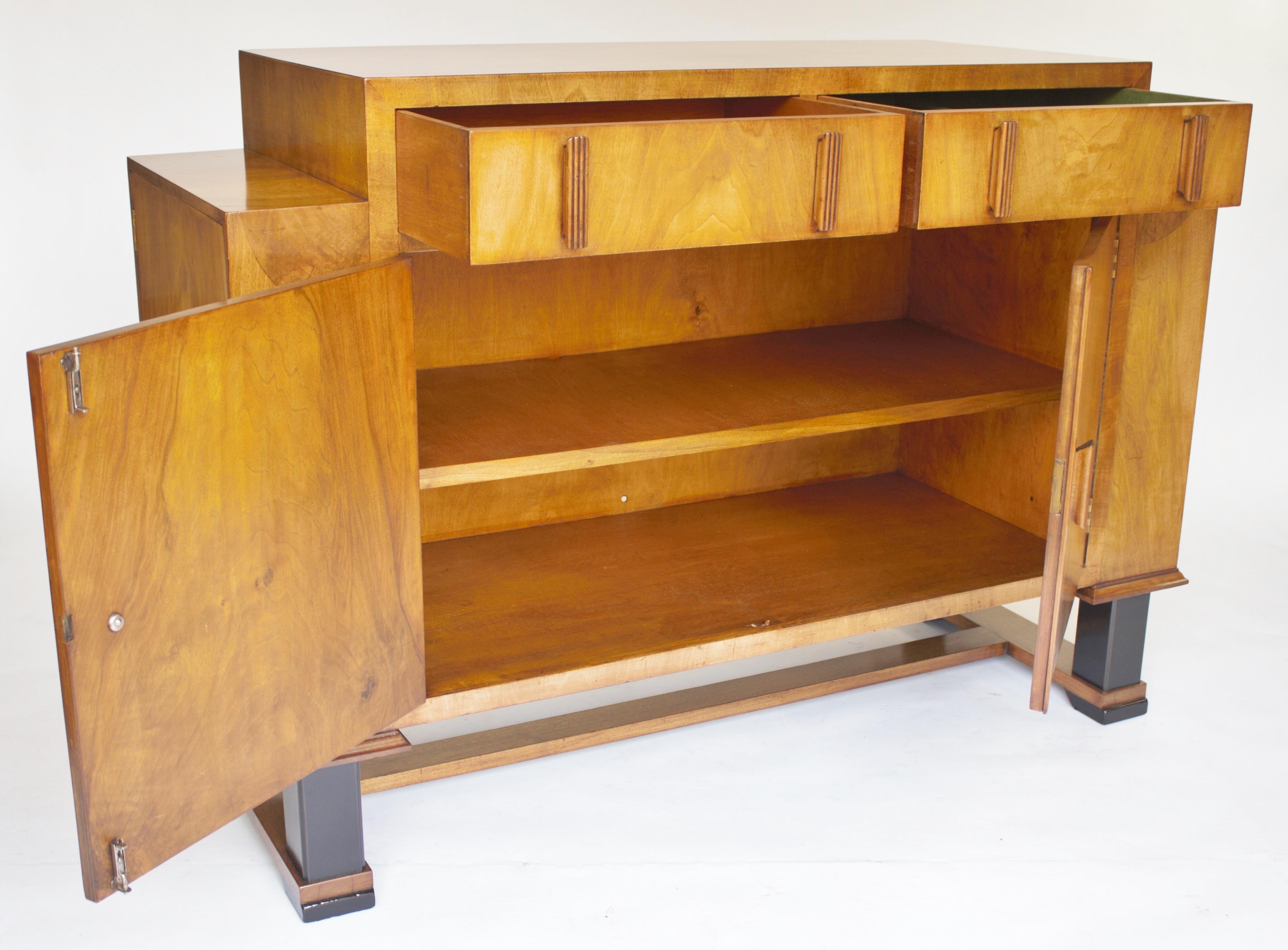Art Deco Walnut Sideboard circa 1930s
Figured Walnut veneer, 
2 drawers at top , R/h drawer lined with green baize for cutlery,
2 doors below with ball catch, open to reveal:
single shelf interior,
Single door cupboards each side, with shelves