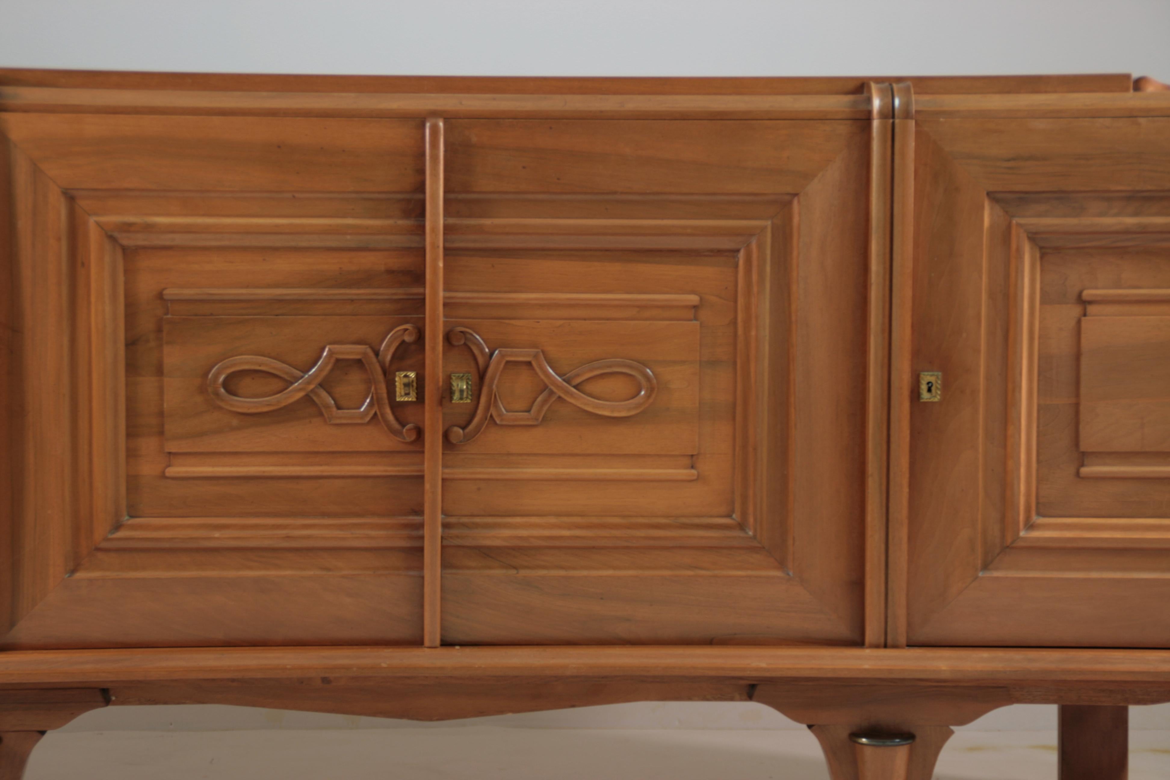 Credenza francese Art Déco in noce risalente agli anni '40. La credenza è composta da tre scomparti con ripiani e cassetti. Le porte sono rivestite con motivi grafici sobri. Lo stile rimane raffinato ed elegante. In buone condizioni