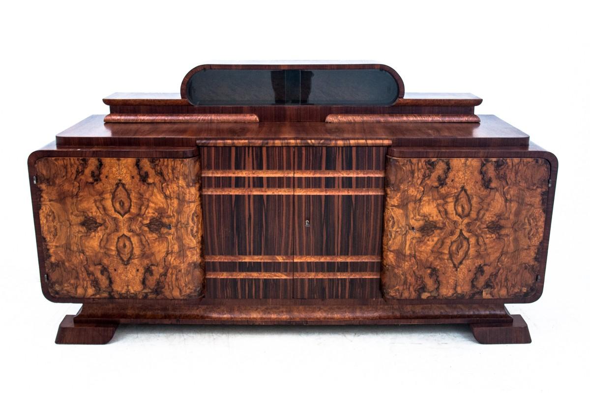 A unique sideboard chest of drawers in the Art Deco style. The chest of drawers was produced in Germany around 1950. Walnut veneered. From the top, a glass extension for storing porcelain and tableware. Very good condition.
Dimensions: height 120