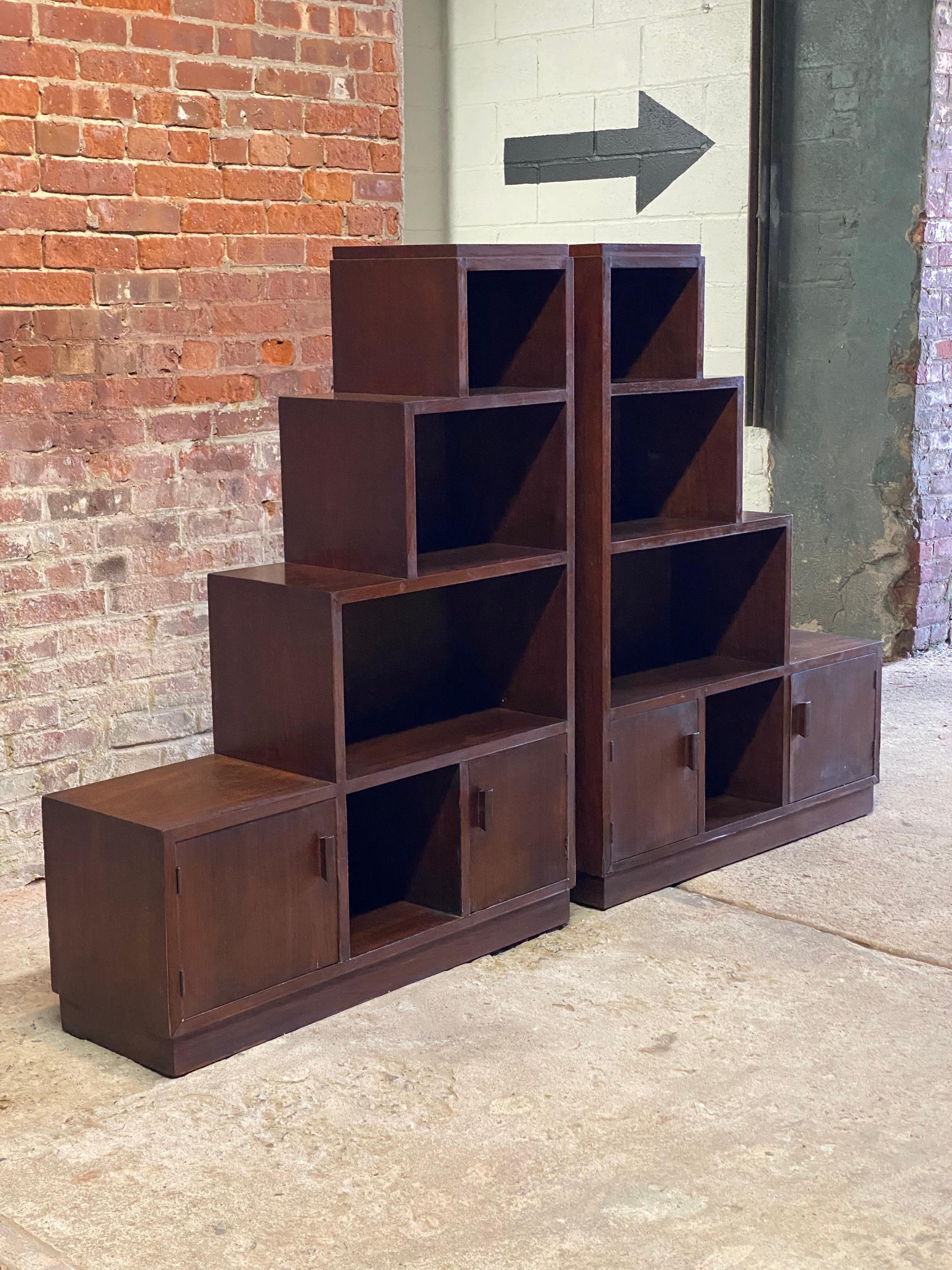 A smart pair of walnut Art Deco skyscraper bookcases. Circa 1930-40. Each cabinet has the stepped hard geometric lines revealing the true aesthetic of the Art Deco period. Nicely figured walnut veneers. Plinth bases. Both have two small doors on the