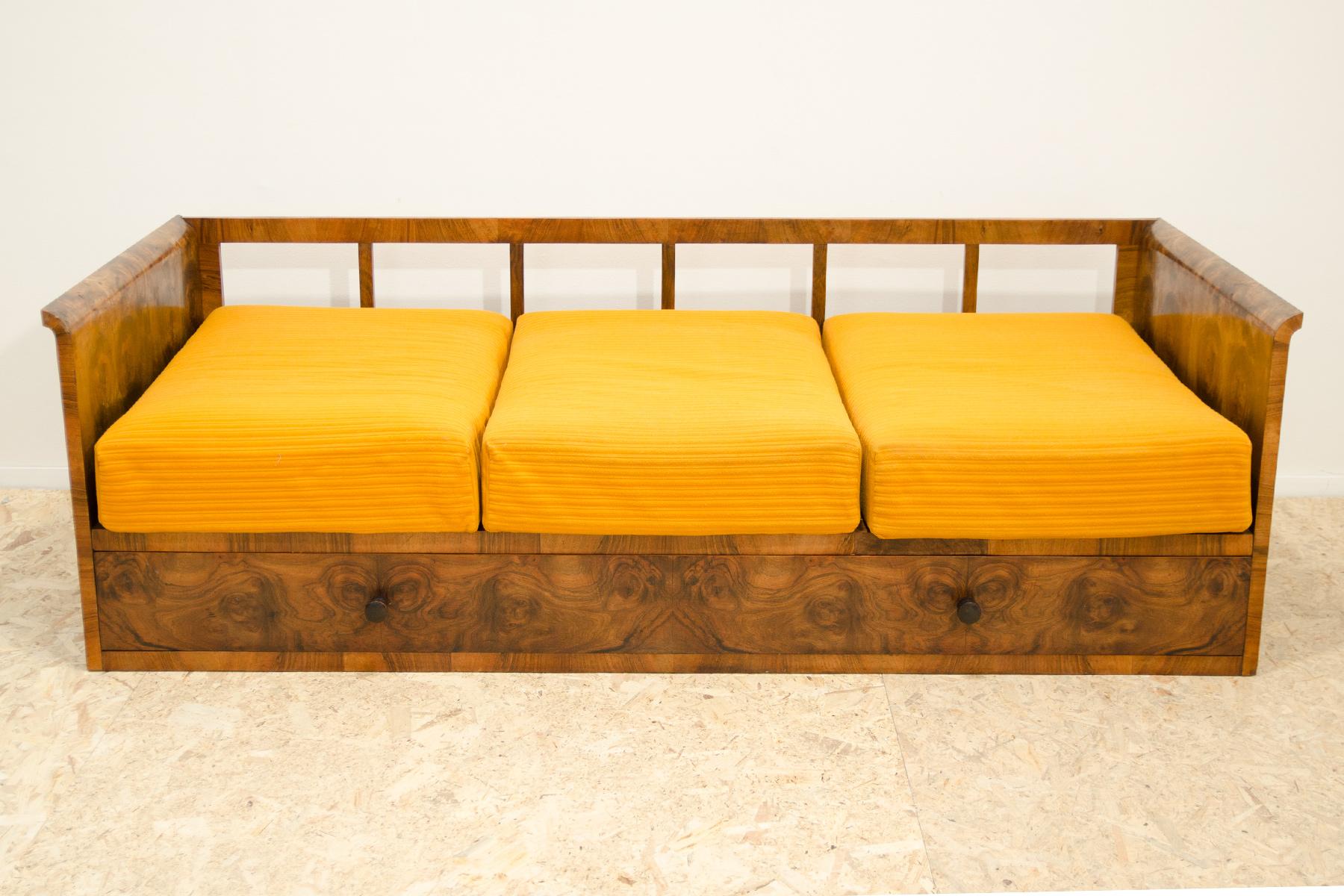 This Art Deco sofa with storage was made in the 1930s in the former Czechoslovakia. This piece is an example of the Czechoslovak Pre-war Art Deco style and it features a wooden structure that is veneered in the walnut. Sofa is in very good