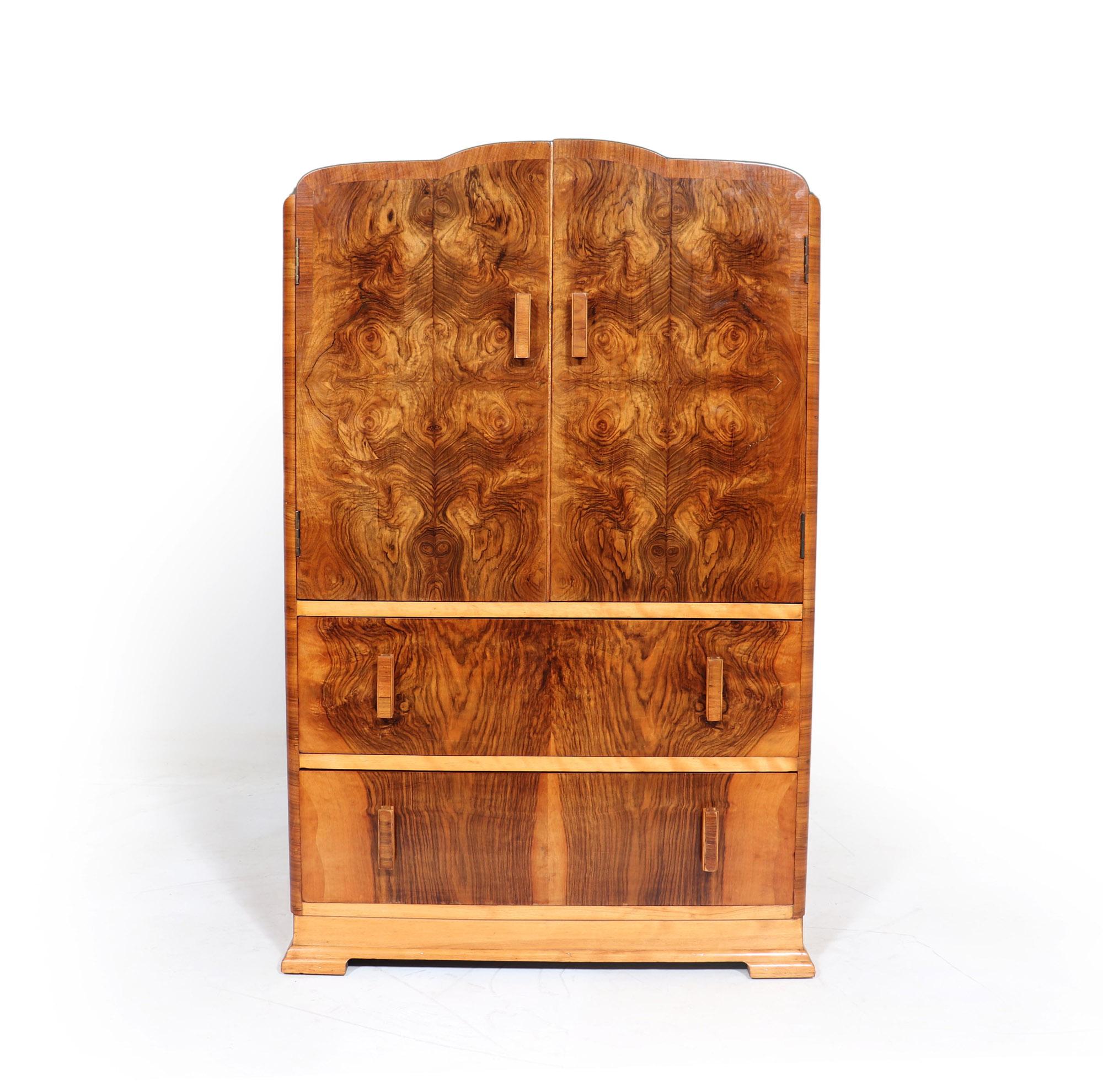 This Art Deco walnut tallboy hast a shaped top pair of doors with shelf behind over two long dovetail jointed drawers, stands on a shaped stepped plinth the tallboy has been restored where necessary and fully polished and is in great condition