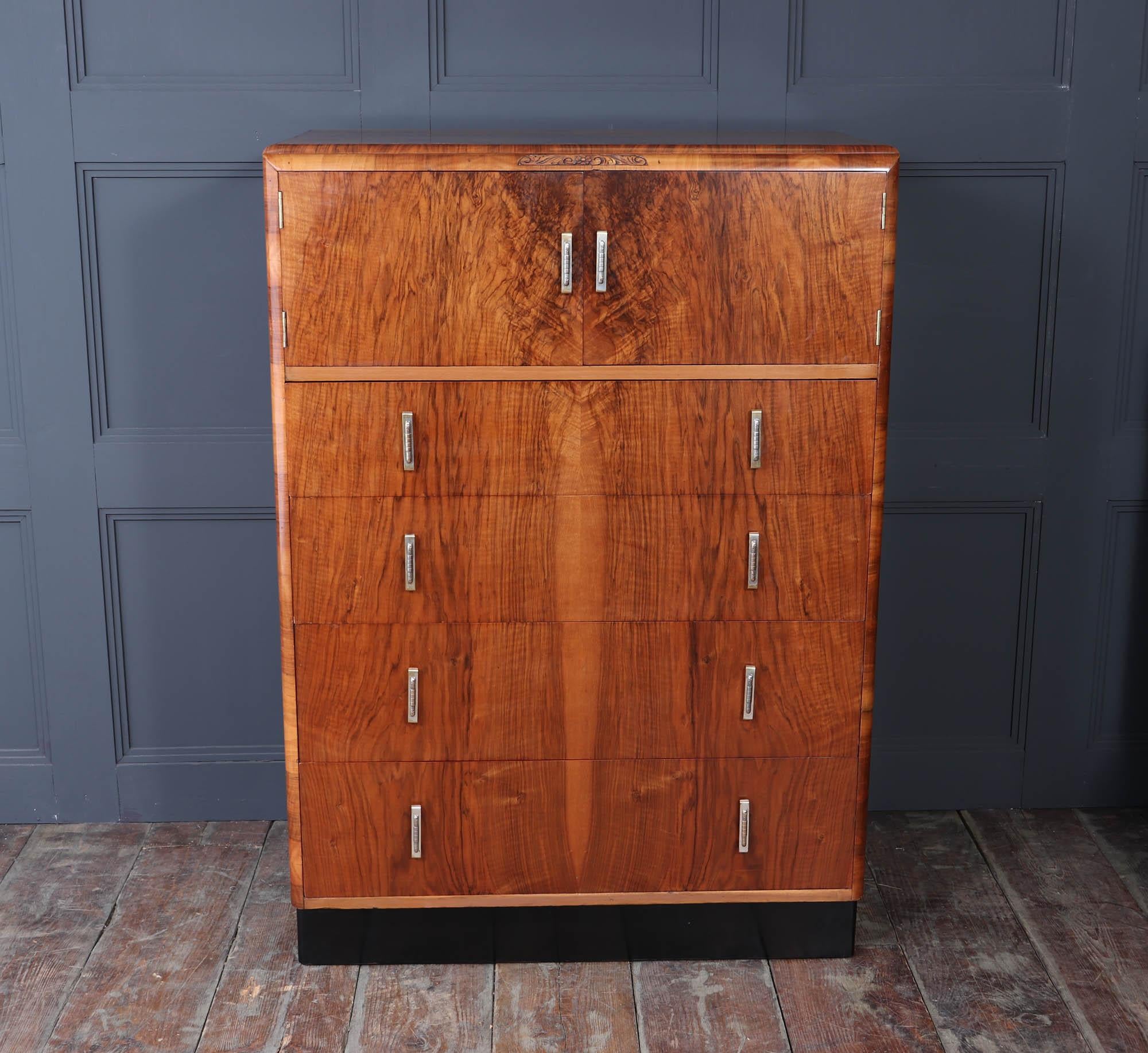 Art Deco Walnut Tallboy c1930
A stunning English art deco tallboy in figured walnut. This remarkable piece features four spacious drawers and elegantly designed cupboards, offering ample storage solutions without compromising on style. The