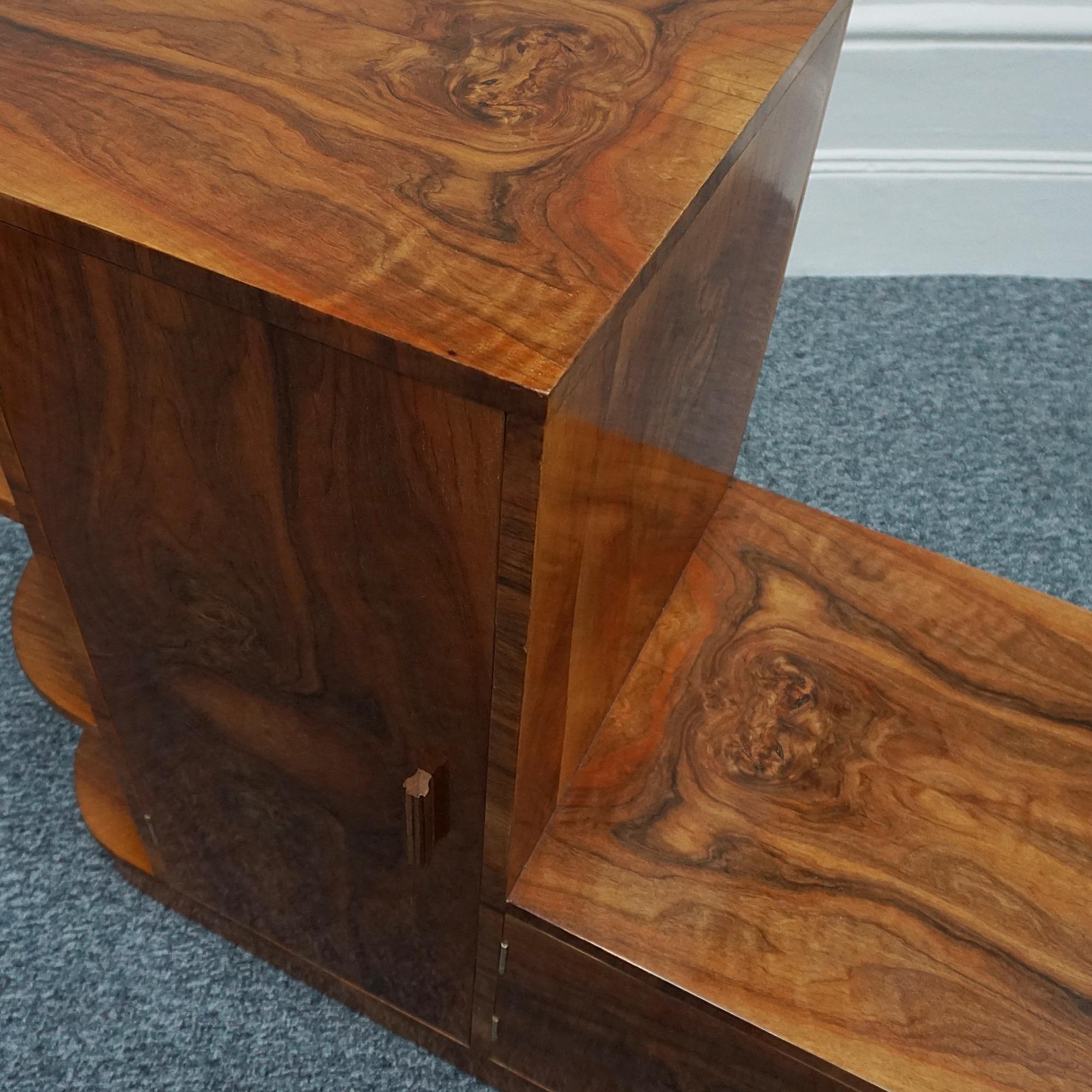 An Art Deco cabinet. Burr walnut veneered with figured walnut banding. Open shelving to the side with two compartments opening up to reveal dividing sections. 

Dimensions: H 91cm W 117cm D 47cm

Origin: English

Date: Circa 1935

Item Number:
