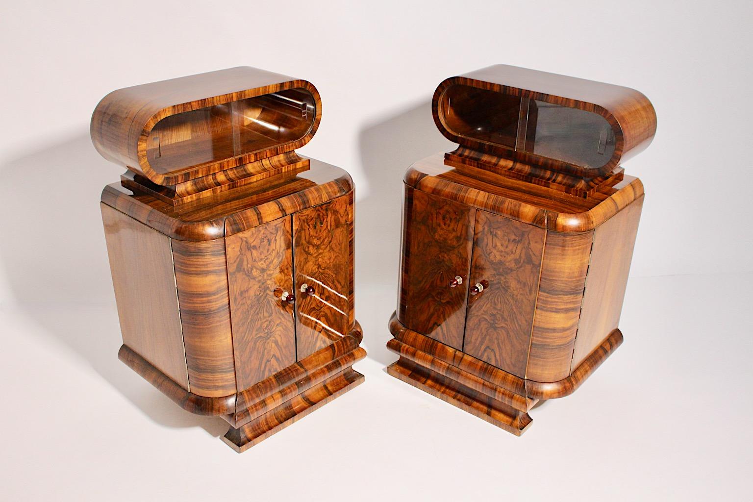 Art Deco vintage pair of nightstands or small chests or commodes from walnut Vienna 1930s.
While the wonderful nightstands show a lively play of walnut veneer and solid walnut in a warm brown color, backside from plywood, the doors feature a round