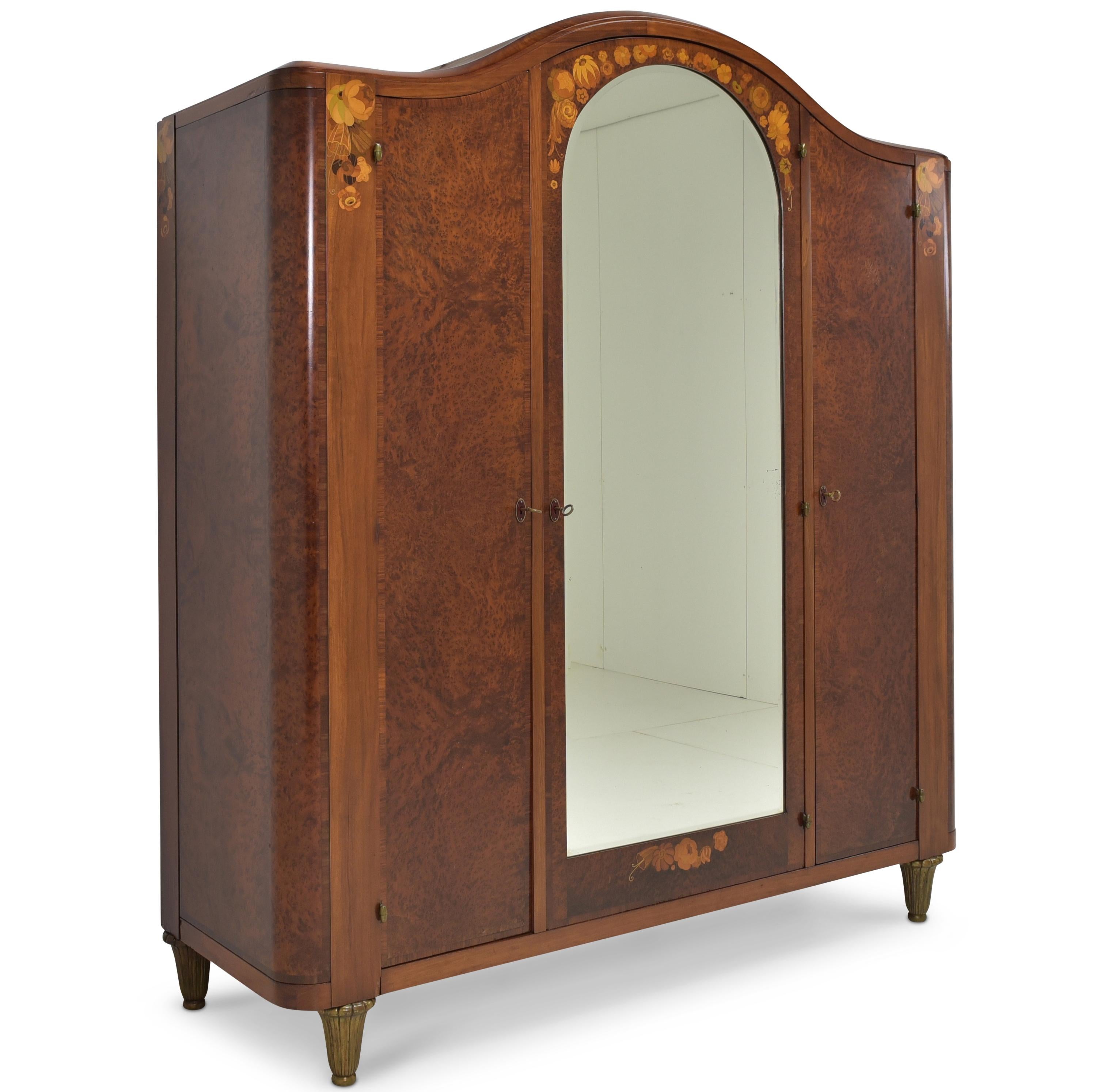 Wardrobe restored Art Deco around 1925 mahogany burl

Features:
Three-door model with mirror, 2 hanging rails and 4 shelves
Height-adjustable shelves
Very high quality processing
Original faceted mirror
Original, high-quality brass feet
Very