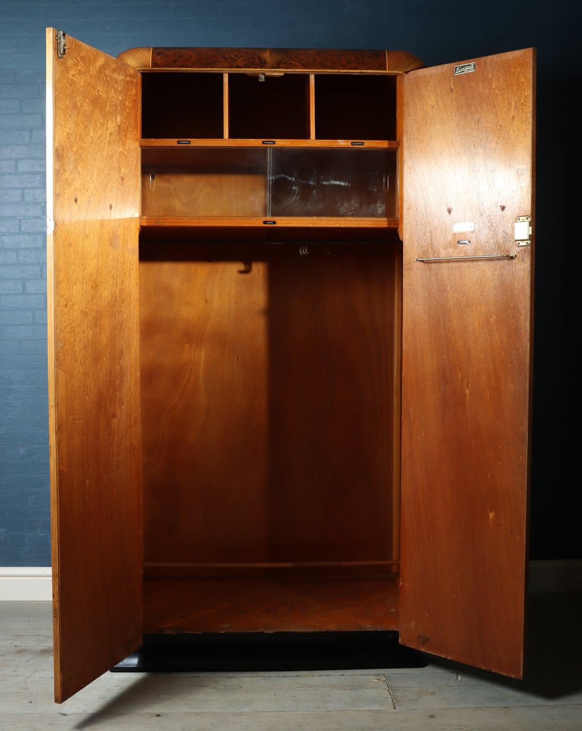 Art Deco wardrobe in walnut
A two door Art Deco wardrobe with figured walnut and burr walnut detail brass hard-wear and semi fitted interior, the wardrobe has been fully polished but does retain some age related marks to the interior.

Age: