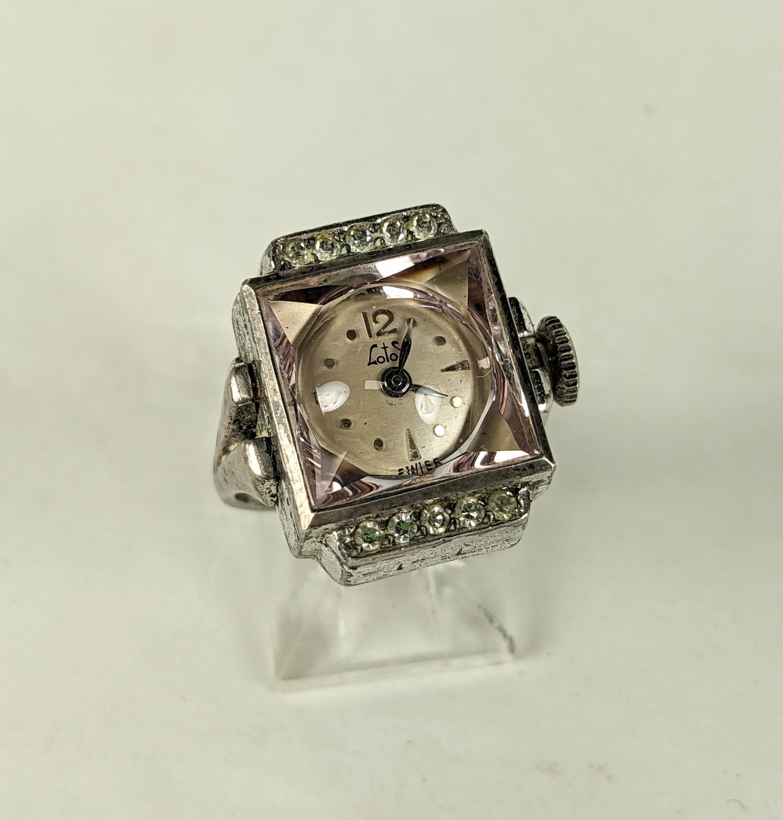 Charming Art Deco Watch Ring with a pink crystal. Set in sterling silver with pastes detailing with faceted pink crystal. Made by Lotos, Swiss made. Watch runs when wound, 1920's USA. Size 6. 