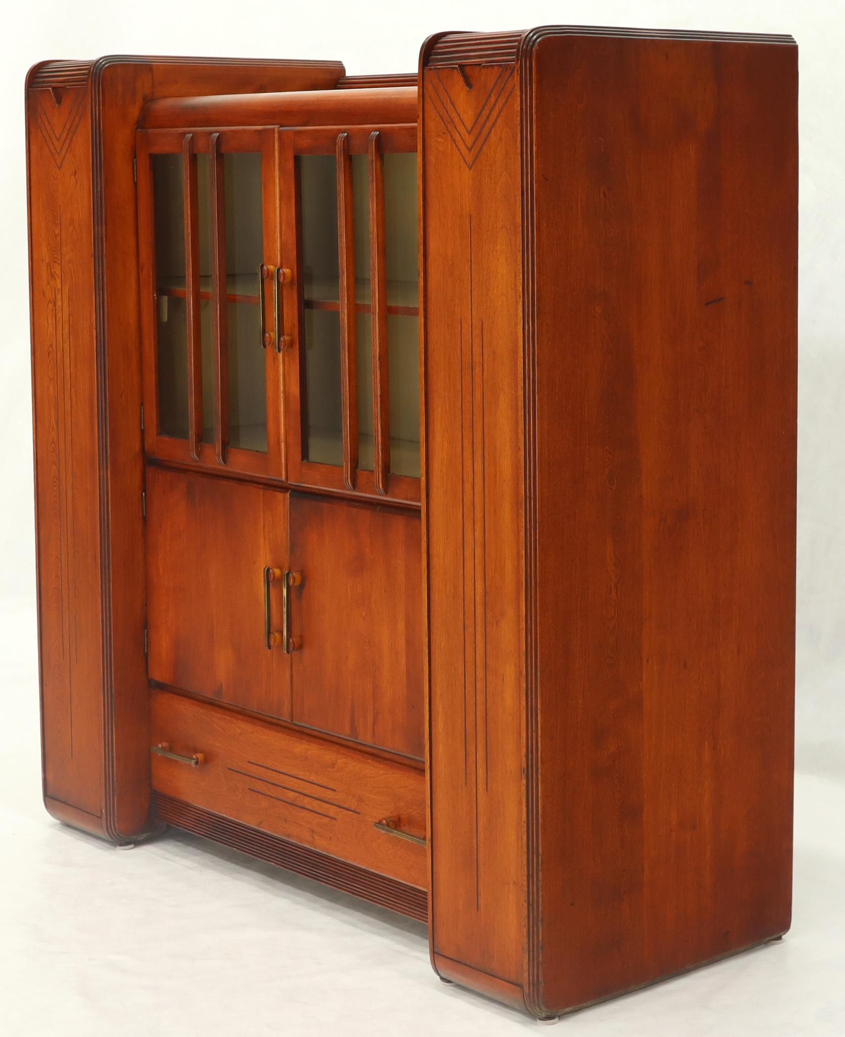 Very unusual multi purpose Art Deco storage cabinet with lid top compartments, back splash, double glass doors, and bakelite and brass hardware. One drawer storage compartment on the bottom. Gilbert Rohde era.
 