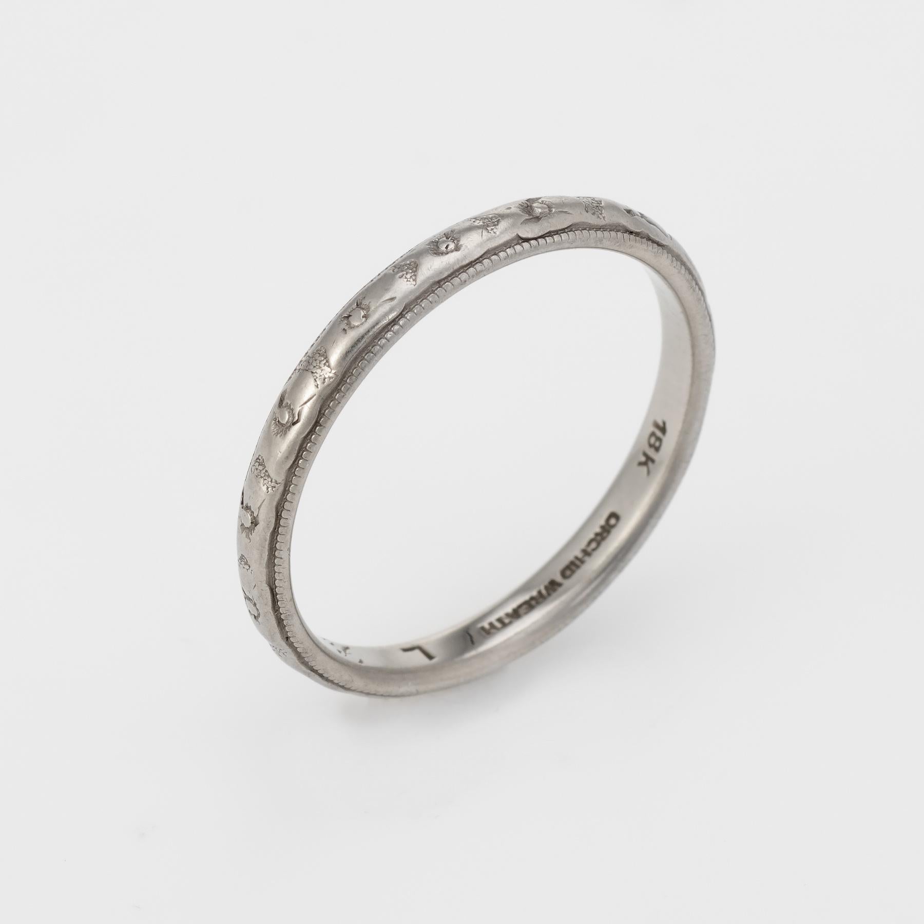 Elegant vintage wedding band (circa 1930), crafted in 18 karat white gold. 

The band features a rosette pattern that is continuous around the ring.      

The ring is in good condition. The pattern has worn down somewhat from wear over the