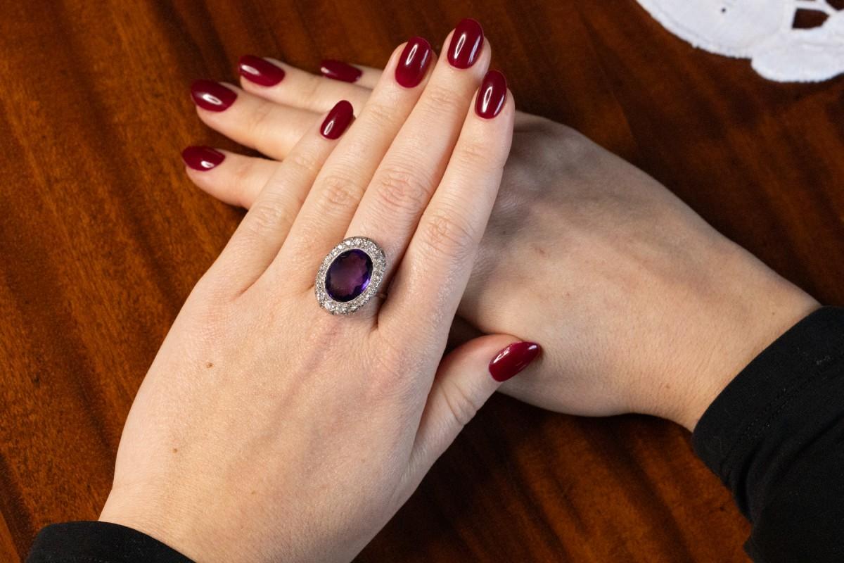 Art Deco amethyst ring from around 1930.

Ring made of 14-karat white gold and platinum. In the center an oval amethyst (its dimensions 15.4 x 11.4 x 6.3 mm), around it 20 diamonds in old brilliant cut with a total weight of approx. 1.00 ct (purity
