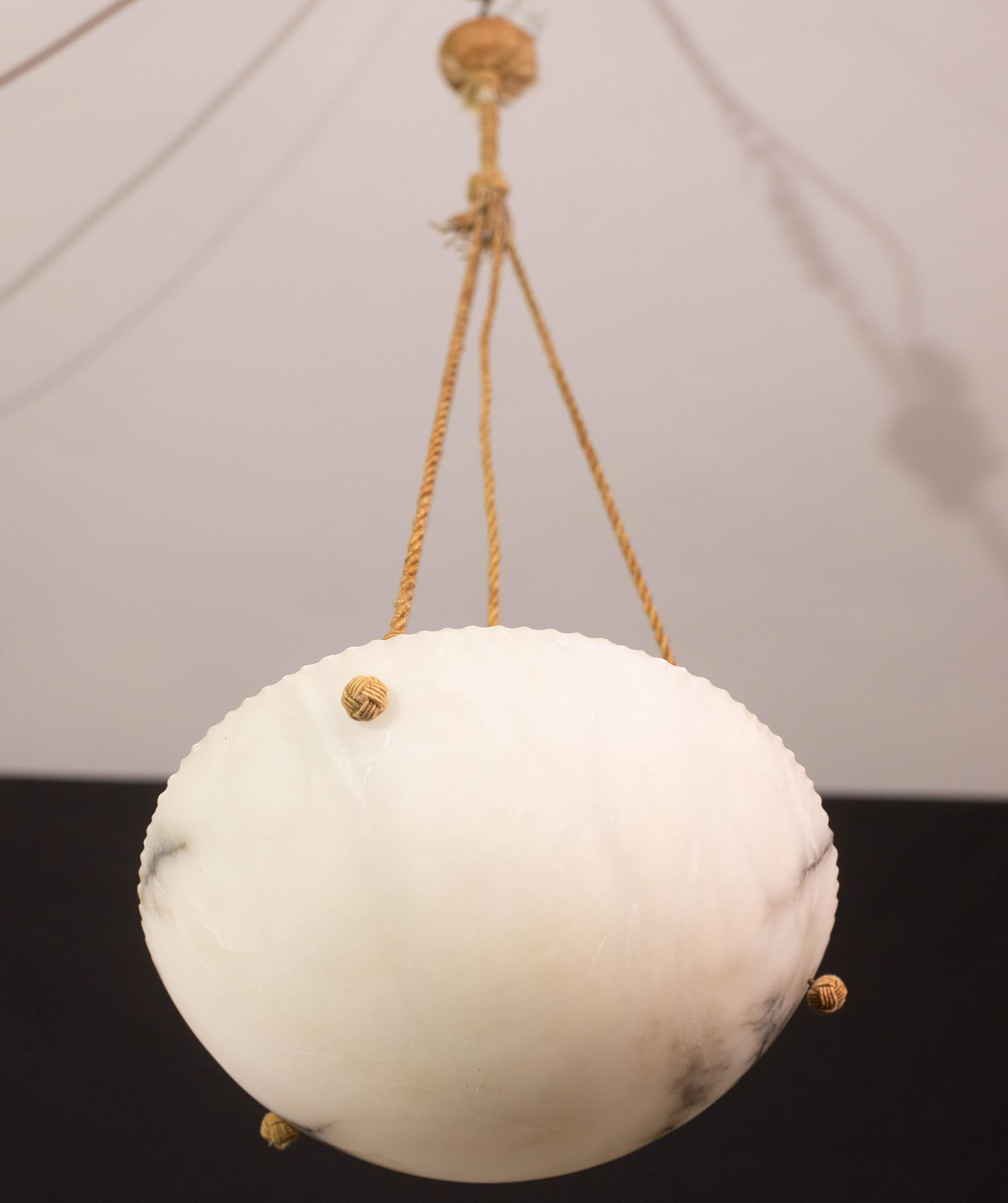 Lampada a sospensione antica in alabastro in stile Art Déco, anni '1940 circa.
Un unico pezzo di alabastro, splendidamente lavorato con sfumature e riflessi di altri colori quando è illuminato, sospeso a tre fili di corda, il suo originale, può