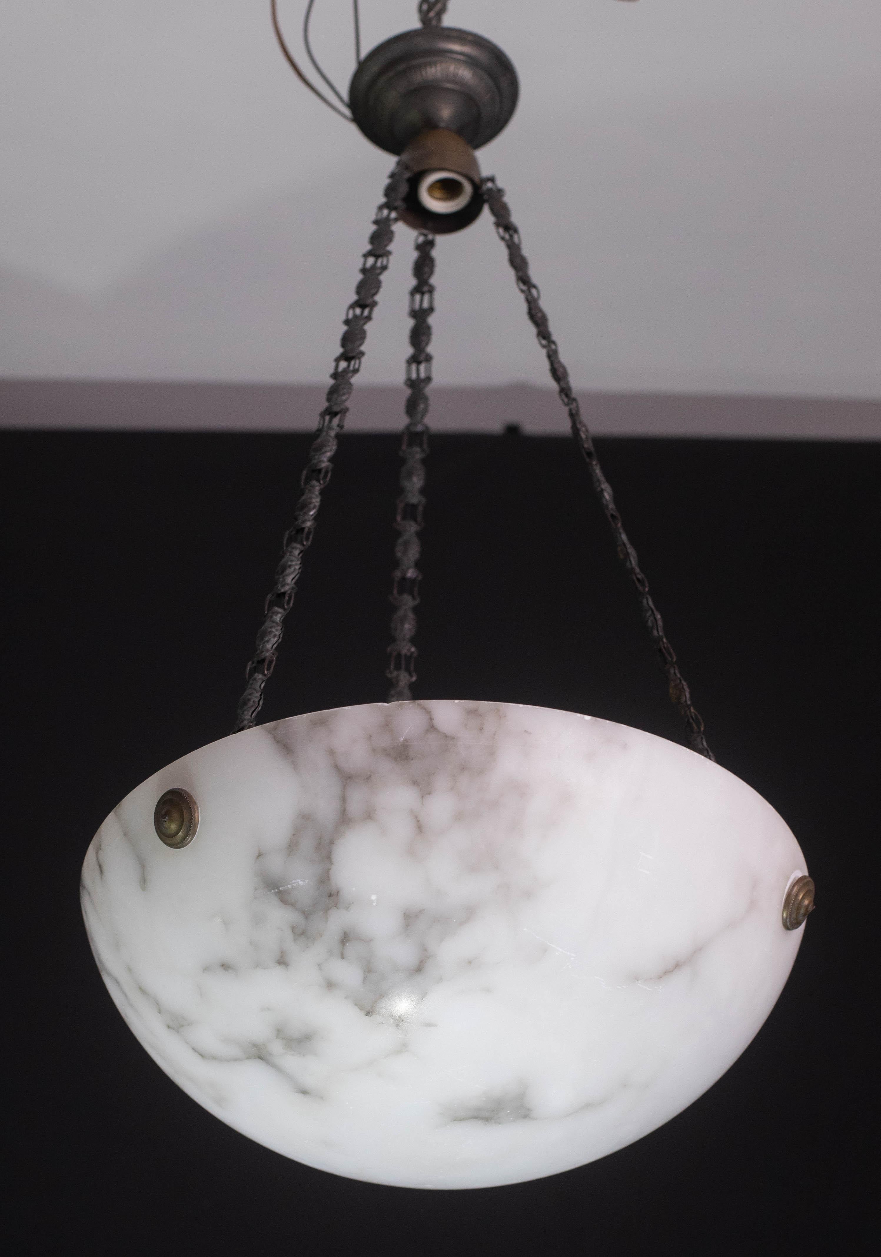 Lampada a sospensione antica in alabastro in stile Art Déco, anni '1940 circa.
Un unico pezzo di alabastro, splendidamente lavorato con sfumature e riflessi di altri colori quando viene illuminato, sospeso a tre fili di catena, il suo originale.
La
