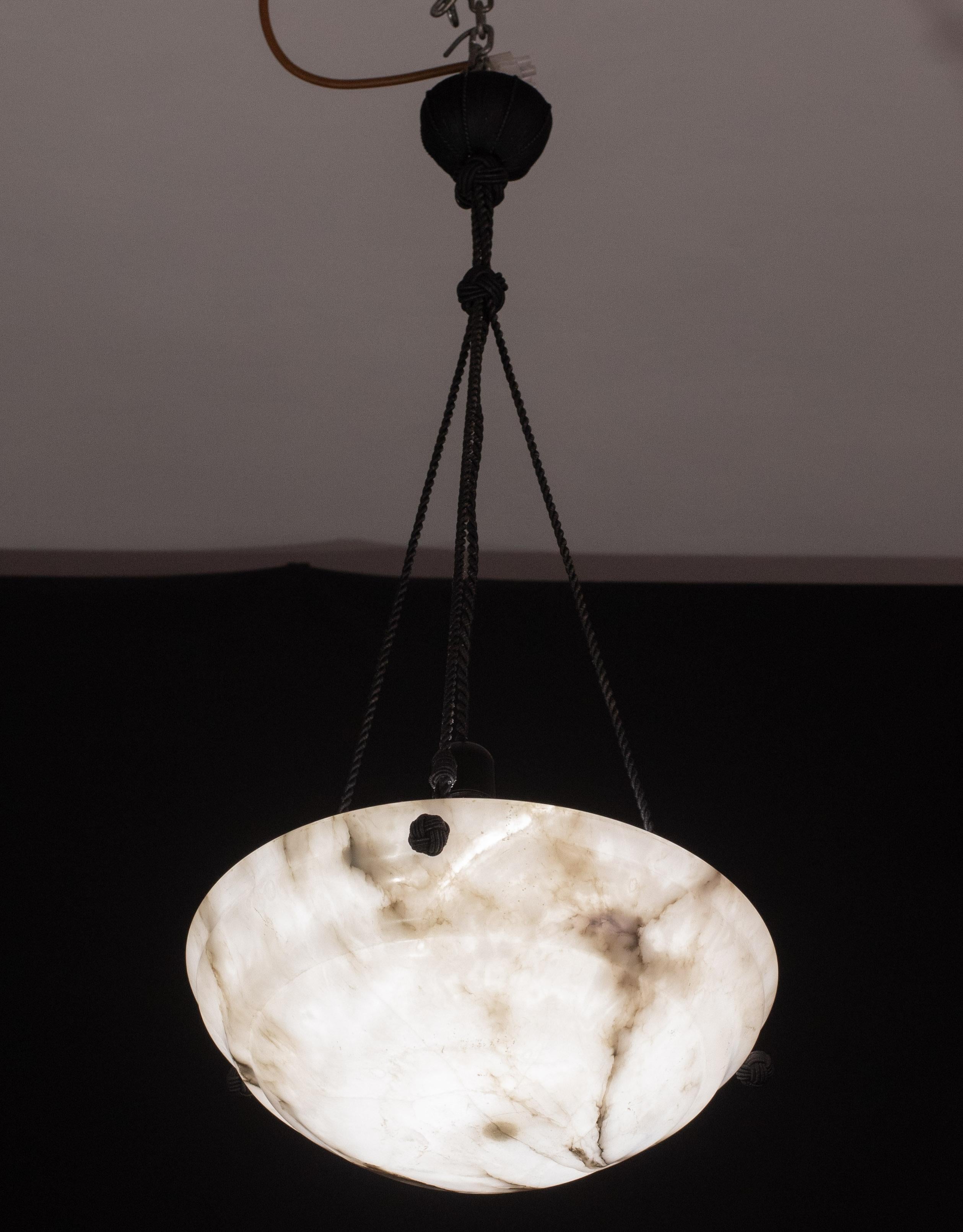 Antike Alabaster-Hängelampe im Art-déco-Stil, ca. 1940er Jahre.
Ein einziges Stück Alabaster, wunderschön gearbeitet mit Schattierungen und Reflexen anderer Farben, wenn es beleuchtet wird, aufgehängt an drei Strängen eines Seils, das Original, kann