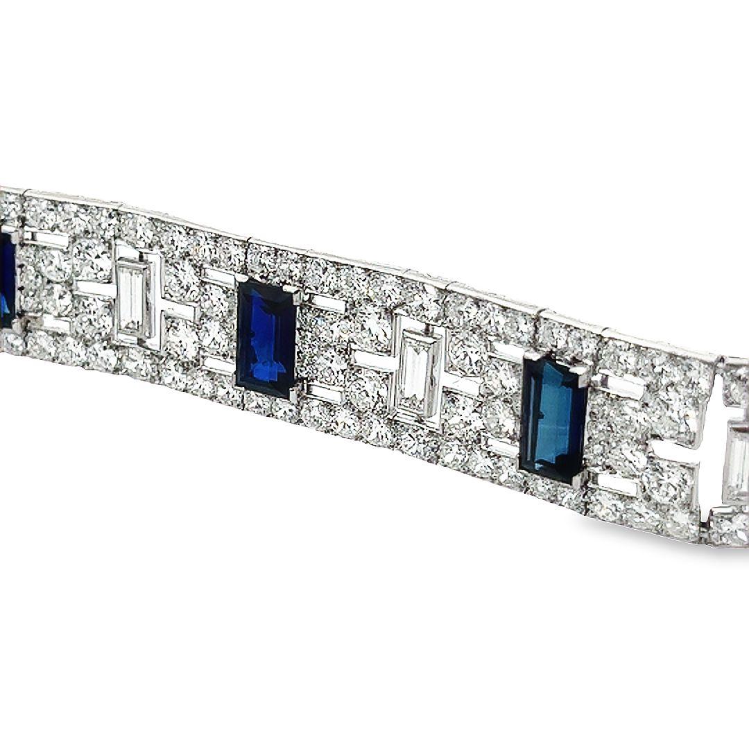 This exquisite art deco diamond and sapphire platinum bracelet has 23 carats of white diamonds and 12 carats of sapphires giving it an unmistakable sparkle and shine.  
The bracelet features round and baguette shape top quality white diamonds and