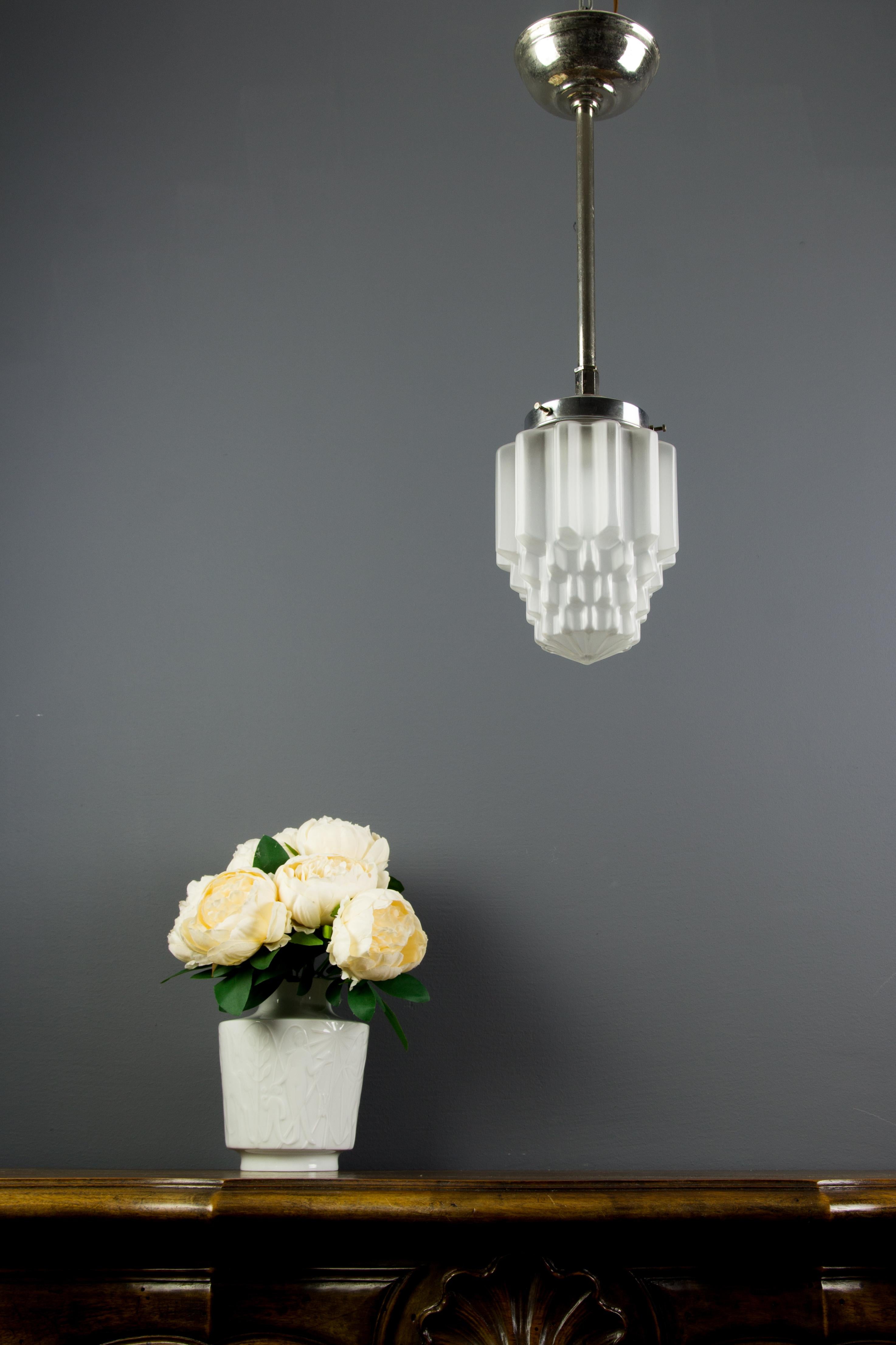 French Art Deco pendant light with skyscraper style white frosted glass shade and chrome fixture, circa the 1930s.
In good condition, wear consistent with age and use, one socket for E27 light bulb.
Dimensions: Diameter 13 cm, 5.11 in, height 45 cm,