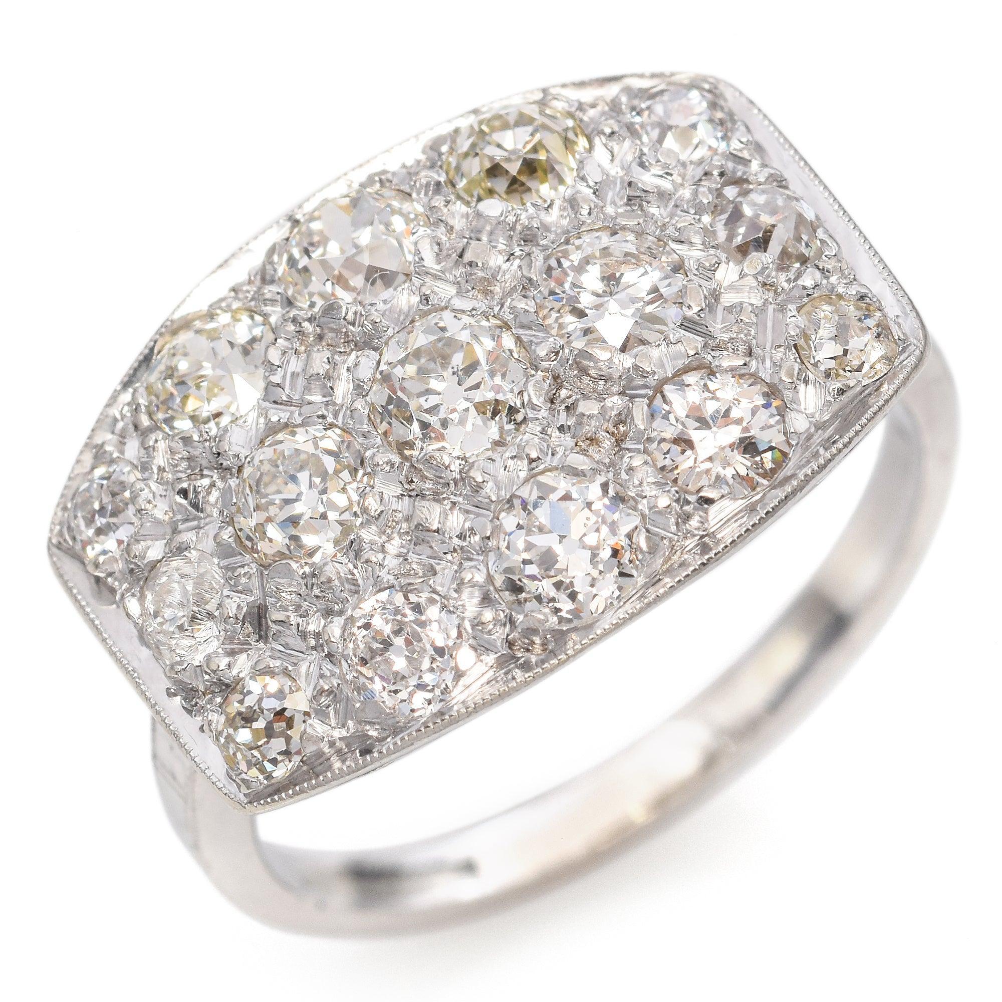 Une éblouissante bague à grappes de diamants Art déco, réalisée en or blanc et sertie de diamants de taille ancienne européenne. La face allongée de style plaque est richement incrustée d'un mélange de pierres centrales plus grandes encadrées par