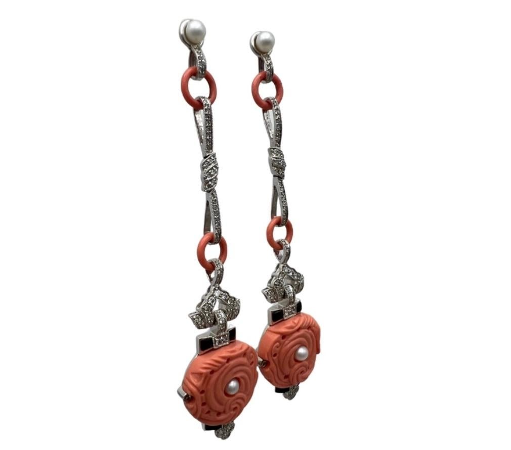 Product details:

The earrings are made out of 18K white gold, carved coral, 1.34 ct of round brilliant cut diamonds, with fresh water pearls and black enamel. It features stud closure.