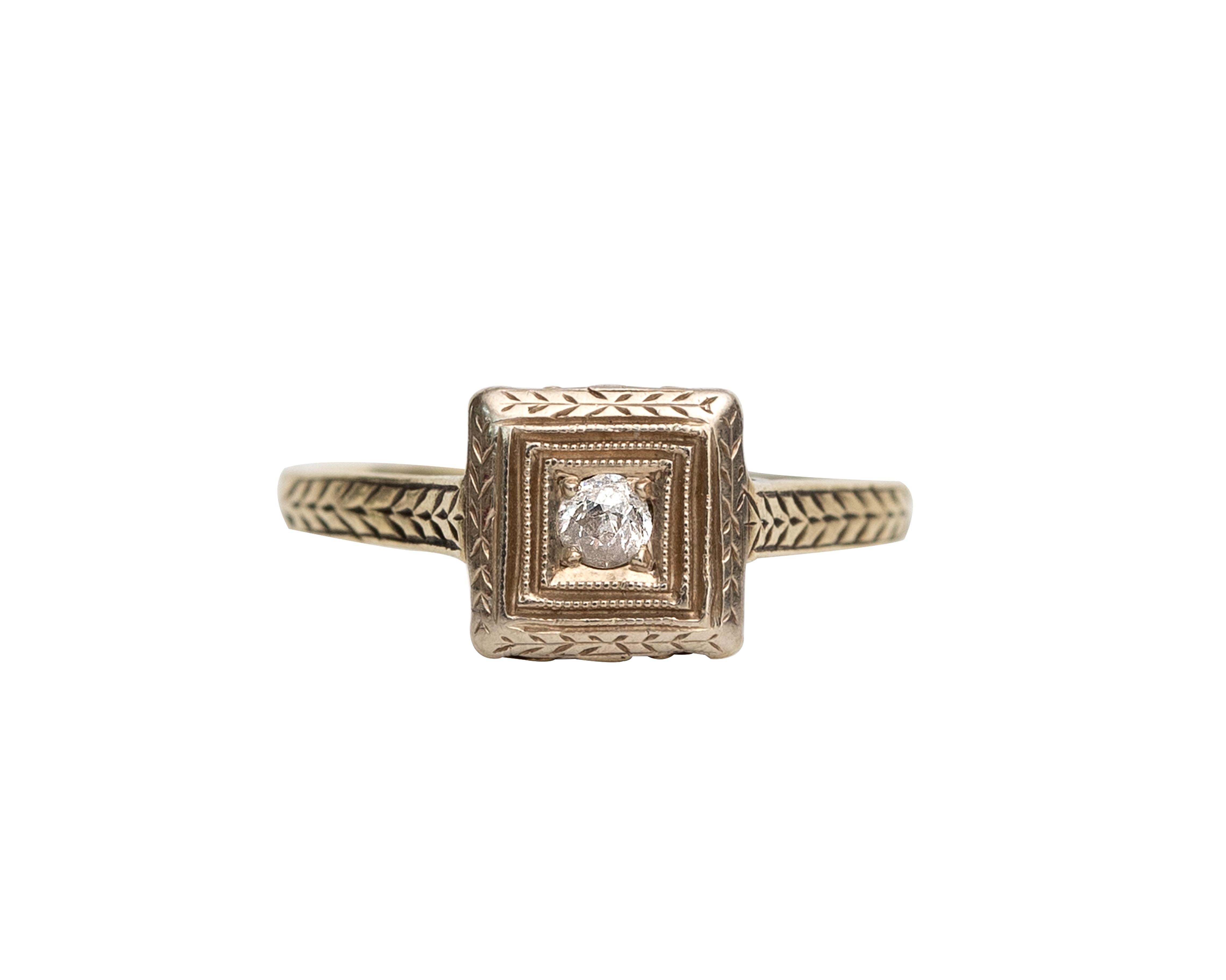 WOW! This Art Deco solitaire is simple elegance! Featuring a .03 carats old minor cut diamond in the center of a square white gold head. The ring has evenly spaced etch design throughout the band on the shoulder of the ring and halfway down the