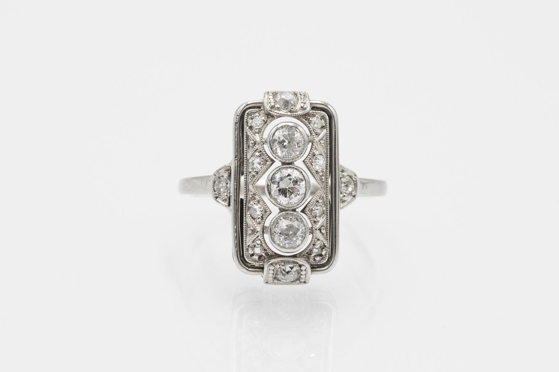 Un anillo alargado de estilo Art Déco geométrico, elaborado en oro blanco de 14 quilates.

Origen: Europa Occidental, años 1930/1940.

La parte delantera del anillo está engastada con tres diamantes talla brillante de transición con un peso