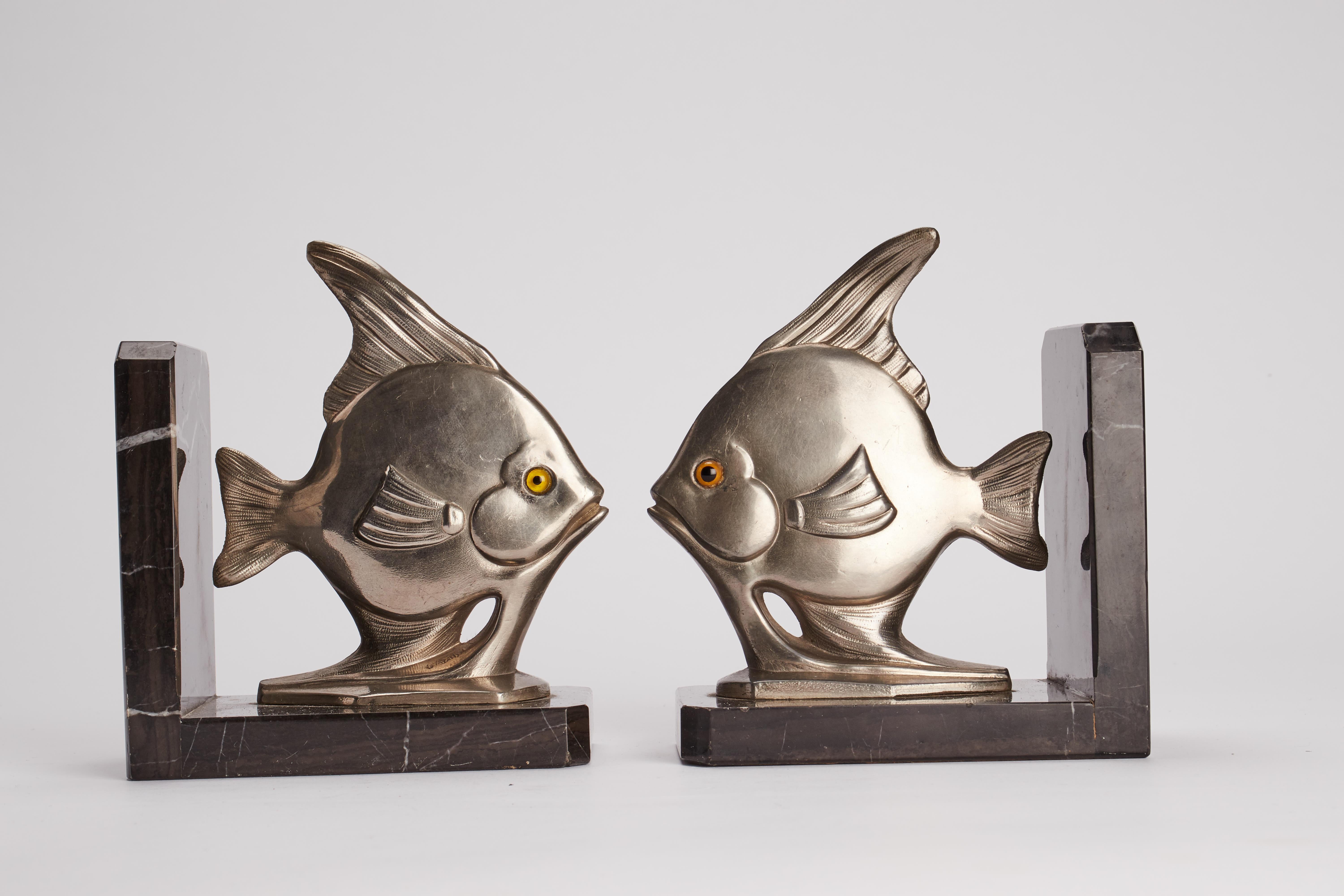 Art Decò bookends, black marble base with white veins, with a pair of fishes , white metal, with glass eyes. France circa 1930.