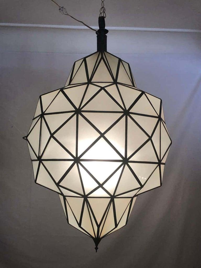 A stunning Art Deco style dome form milk glass white chandelier or lantern. Having individual panes, possessing an open door pane leading to a recently wired setting housing a once candelabra light. The pendant is made with white milk sanded glass