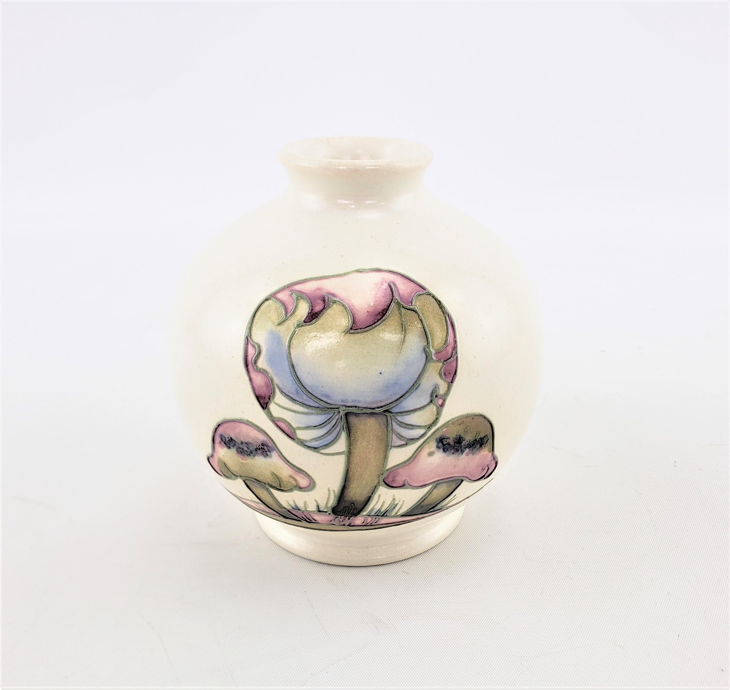 This small bulbous shaped art pottery vase was done by William Moorcroft of England in approximately 1920 in a period amArt Deco style. The vase is done with a white salt glaze ground in the ‘Claremont’ pattern in muted pastel tones and the