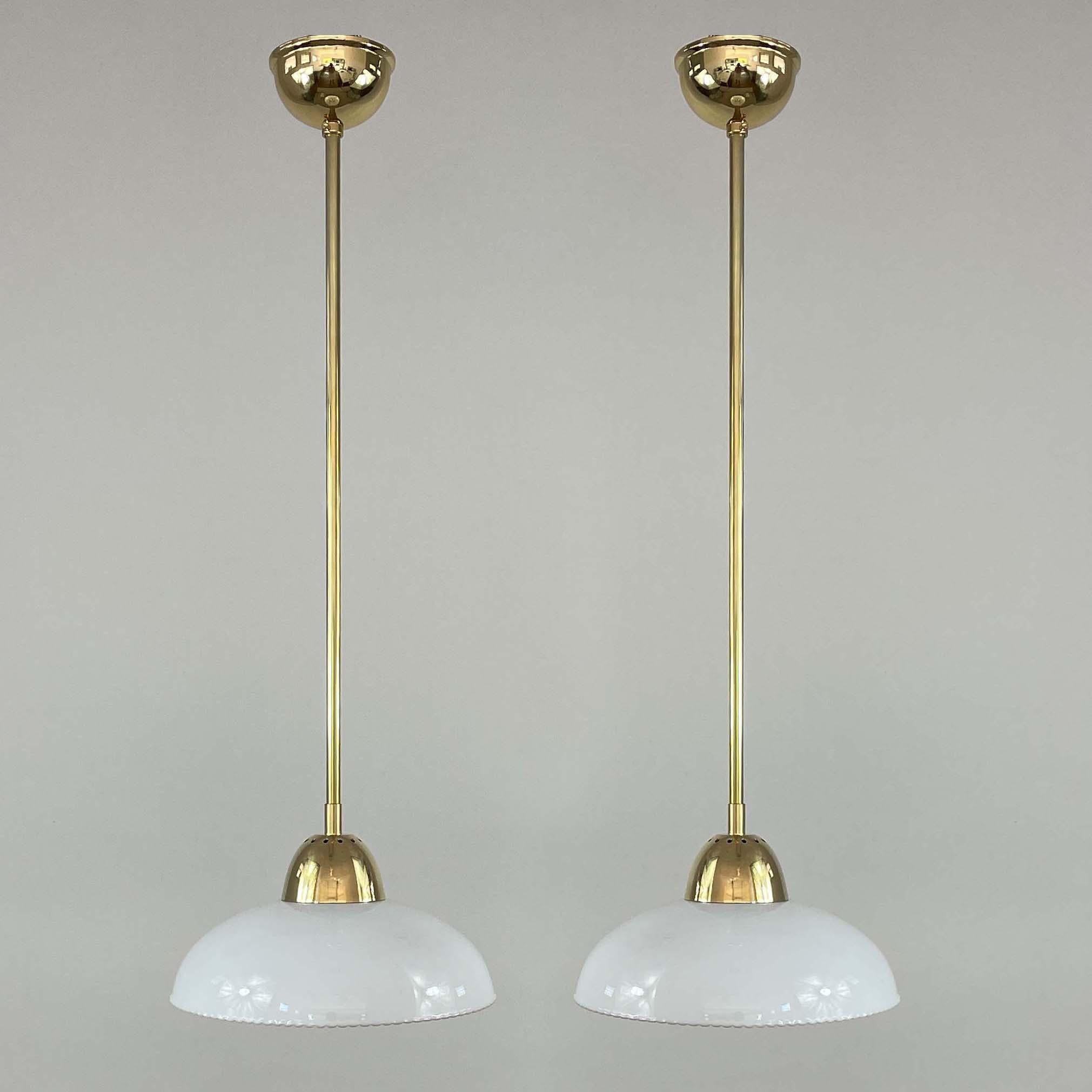 These elegant pendants were designed and manufactured in Sweden in the 1940s. The lights feature white opaline glass shades with a beaded edge and brass hardware. Good vintage condition with one E27 socket each.

The lamps have been rewired for use