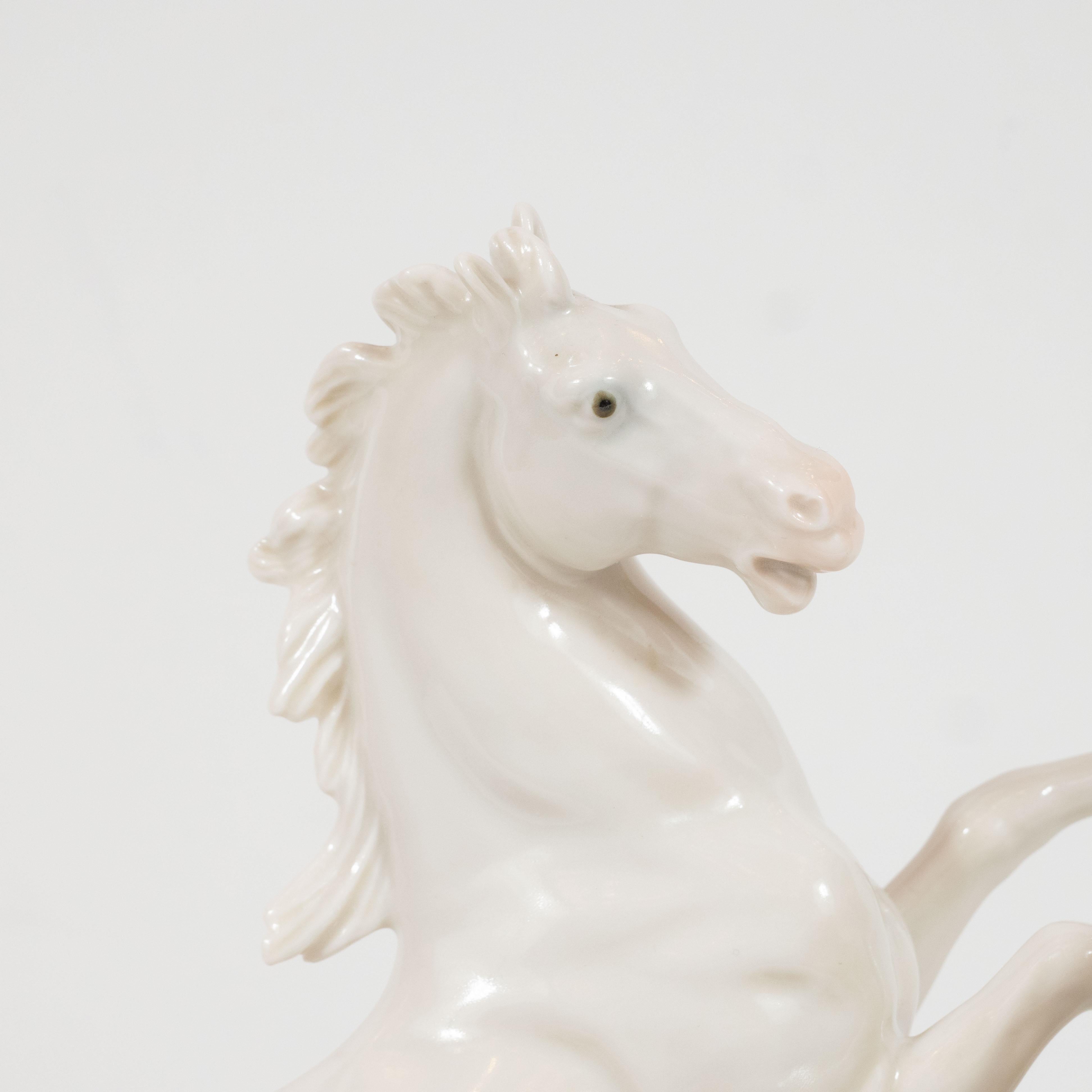 This stunning and dynamic white porcelain sculpture was realized by the esteemed artisan Karl Ens in East Germany, circa 1930. It depicts two galloping horses- a stallion and a mare- in white porcelain with gray-blue eyes, offering the only flash of