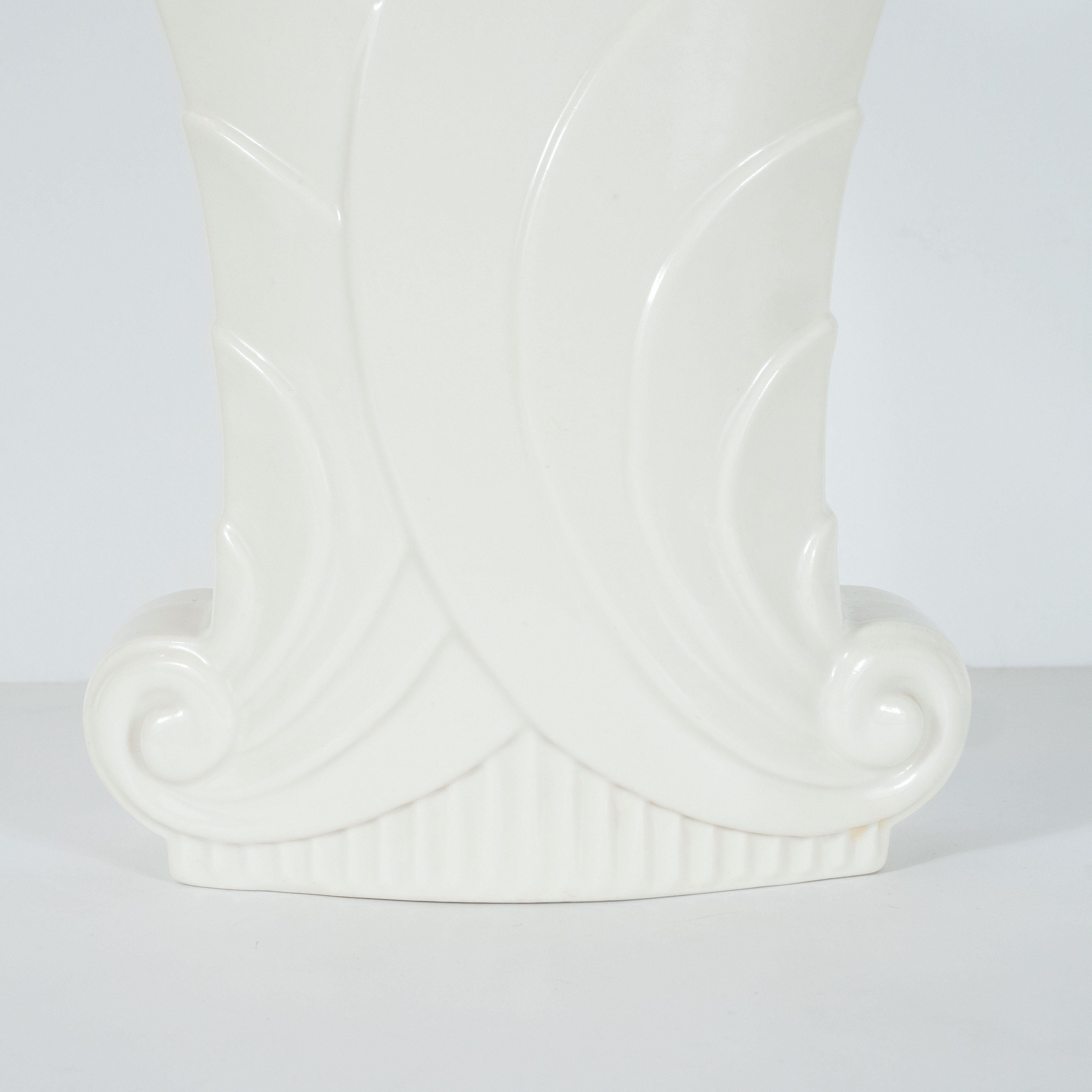 This refined Art Deco vase was realized in the United States by the esteemed maker Abingdon Co., circa 1940. It features a reeded base, and a stepped rectangular body overlapping tiered stylized scroll forms culminating in a v-form mouth. With its