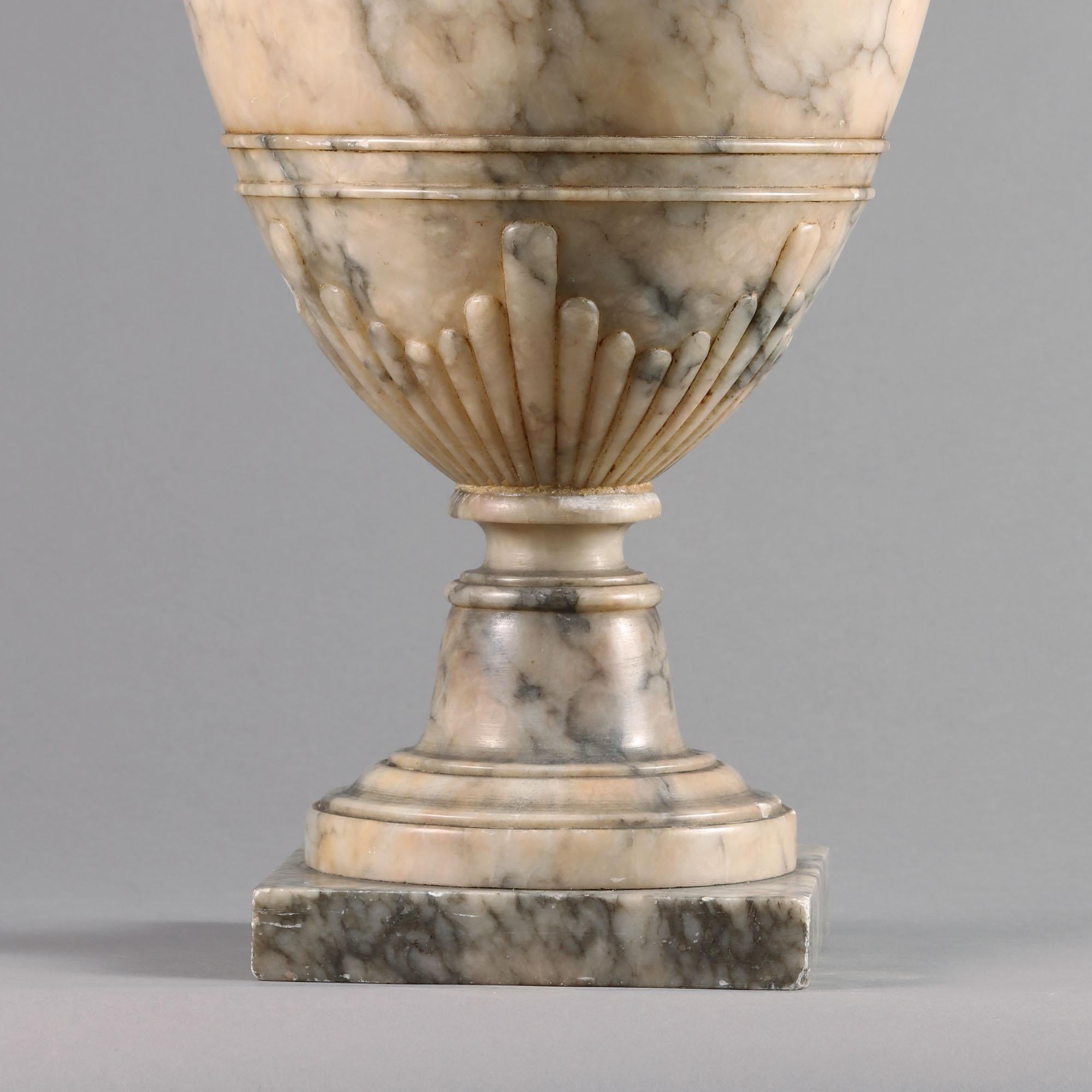 A fine 19th-20th century carved alabaster urn and cover, the turned lid with drop finial, the vase body with handles as stylized bird heads. Raised on a square base,
France, circa 1930

This fine alabaster urn is neoclassical in style

It is a