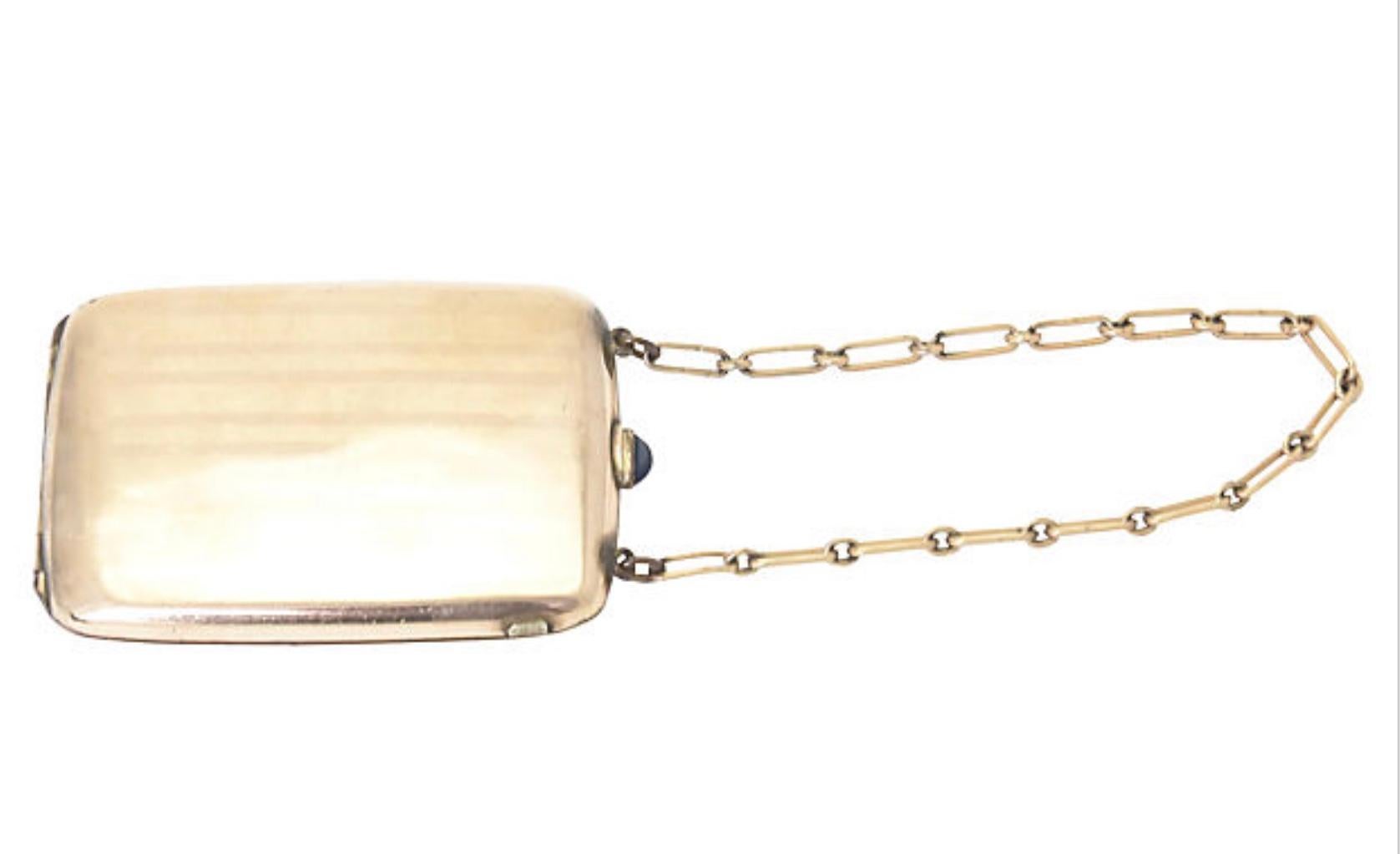 Art Deco Wightman & Hough Gold Filled Compact Purse featuring an etched line design with an area on the front to add initials. I have a faux sapphire push closure and hangs from an open link oval & round link chain. Inside one side is a mirror the