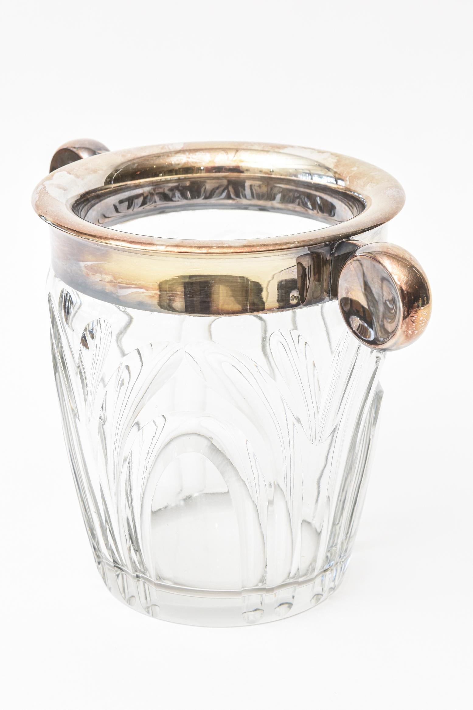 This heavy and fabulous Art Deco WMF silver plated and crystal ice bucket is from the 1930s and most unusual. The flattened circular sculptural handles at either side make for a great carrying presentation. The incised cut-out glass is one of an